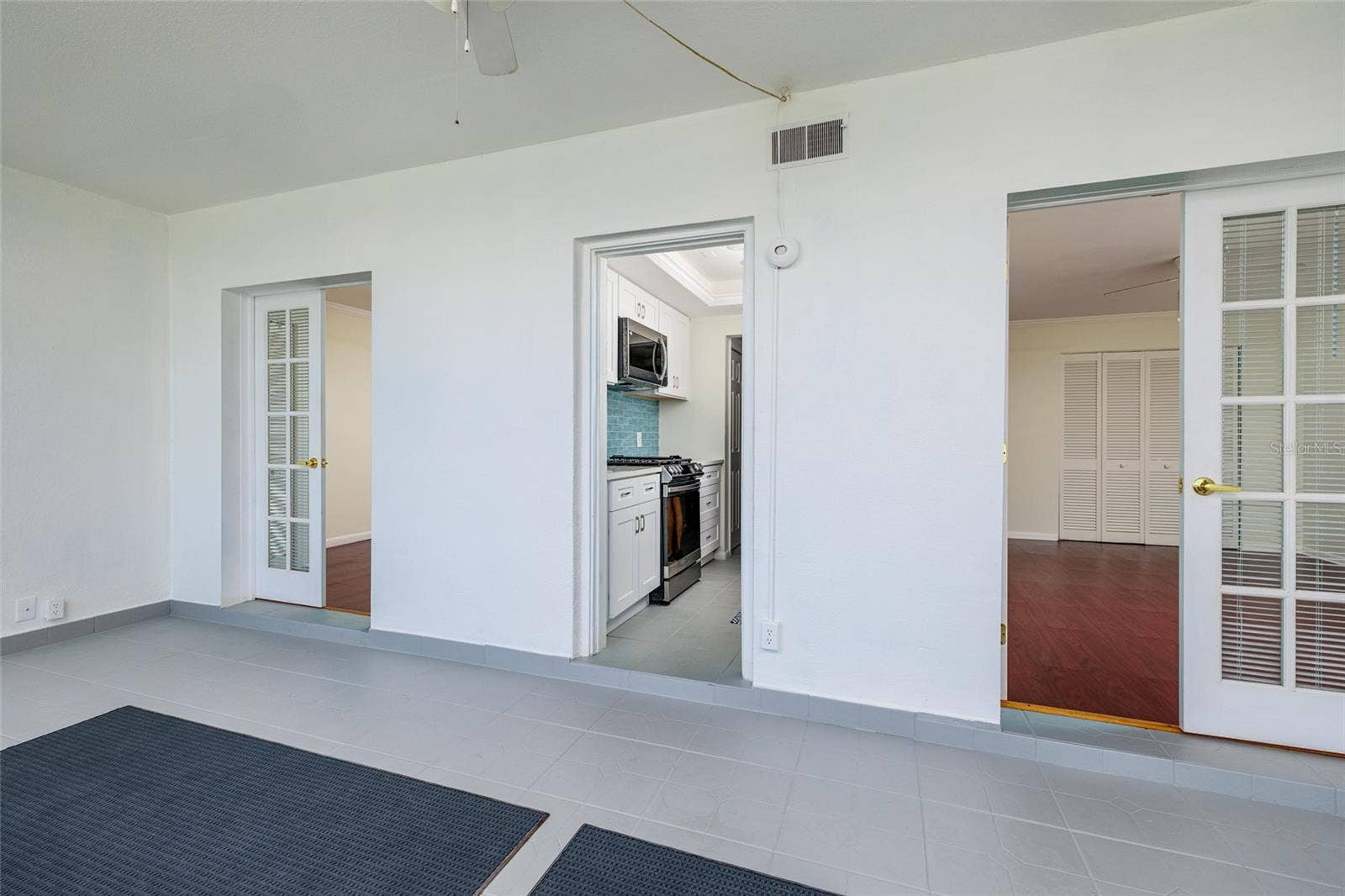 1893 SHORE DRIVE S, #209, South Pasadena, FL 33707 Florida room w/Primary bedroom on right, 2nd bedroom on left & kitchen in the middle.