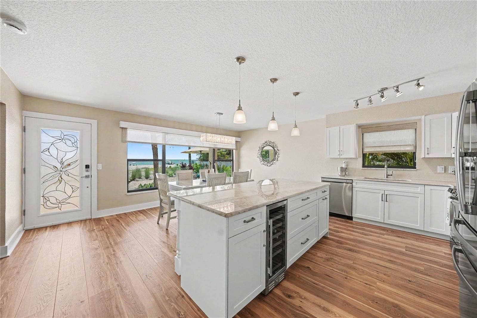 19936 GULF BOULEVARD, Indian Shores, FL 33785 Quartzite counters, oversized kitchen island and space for a large dining room, new cabinets, appliances, 4" baseboards, paint, and flooring. Enjoy remote window shades with expansive views of the beach from both the living room and kitchen. Bonus kitchen window allows for Florida breezes too!