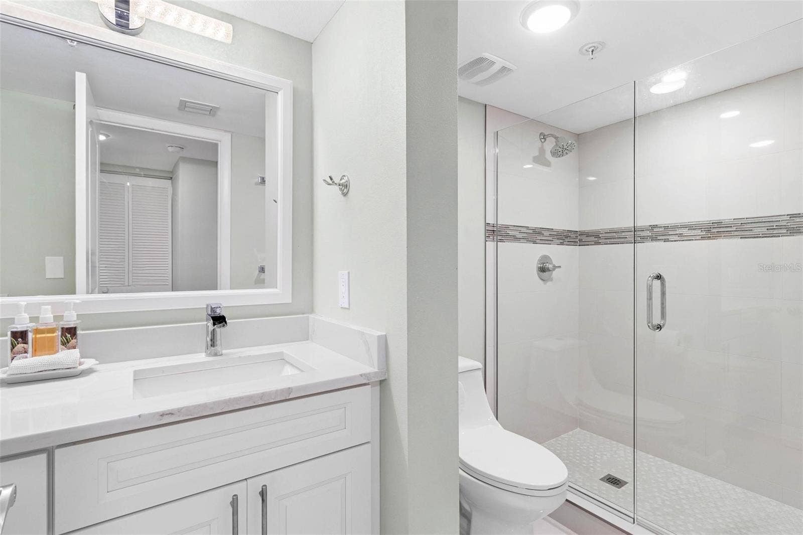 1660 GULF BOULEVARD, #607, Clearwater Beach, FL 33767 guest bathroom vanity and separate commode / shower area