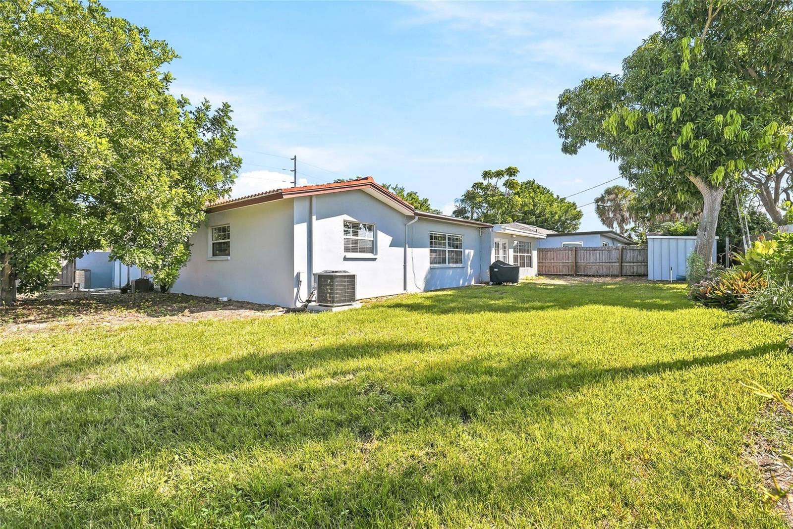 1890 62ND AVENUE S, St Petersburg, FL 33712 Room to enjoy the outdoors, with a broad backyard lawn and mature trees creating an inviting setting for gardening, games, or weekend gatherings.