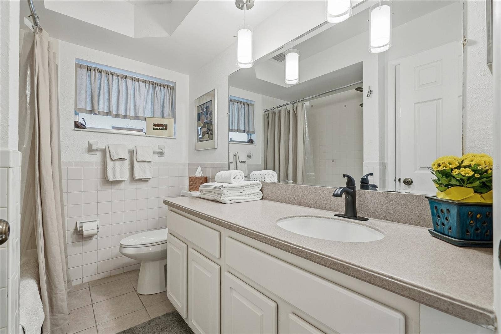 1890 62ND AVENUE S, St Petersburg, FL 33712 A generous vanity, broad mirror, and pendant lighting create a bright, comfortable space to get ready, with cabinet storage below.