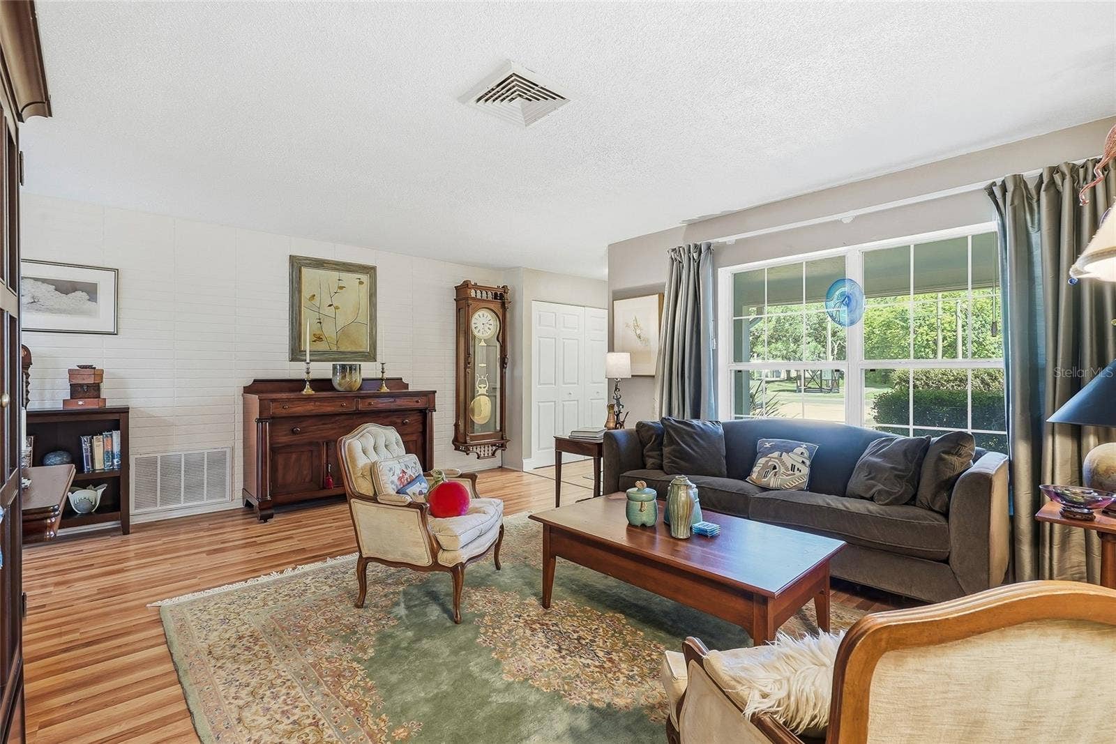1890 62ND AVENUE S, St Petersburg, FL 33712 A generous front window frames leafy views and fills this welcoming gathering space with natural light.
