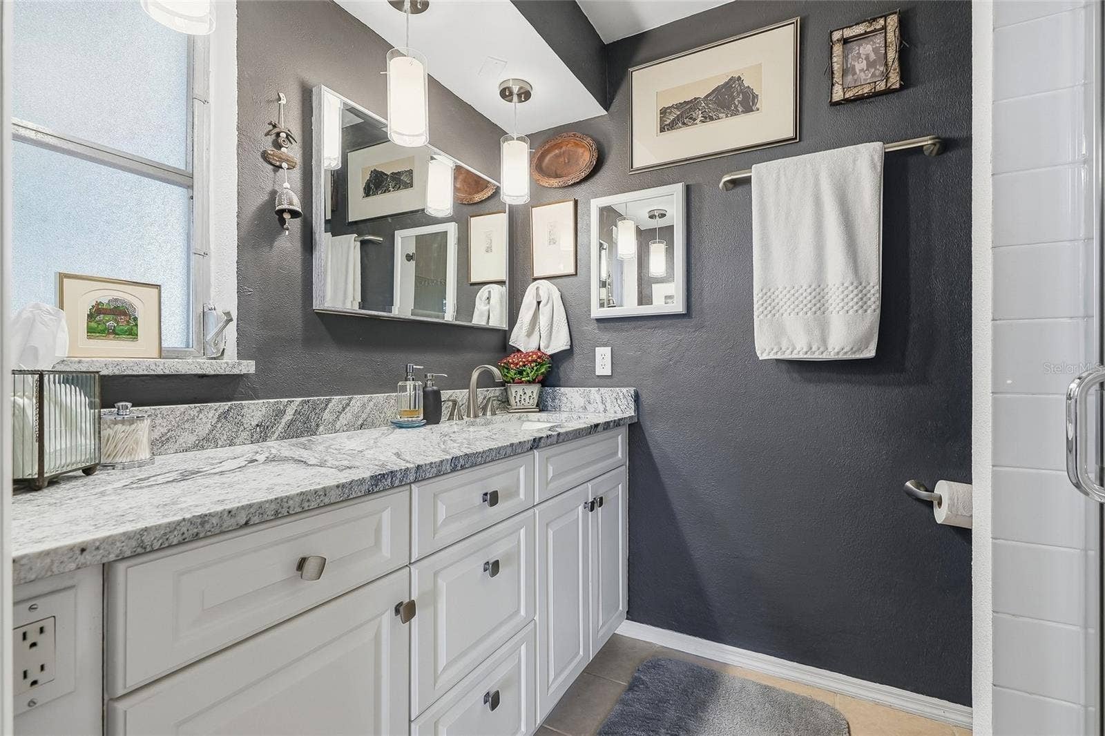 1890 62ND AVENUE S, St Petersburg, FL 33712 Start your day with generous vanity space, plentiful drawer storage, and pendant lighting that adds a stylish touch to the primary bath.