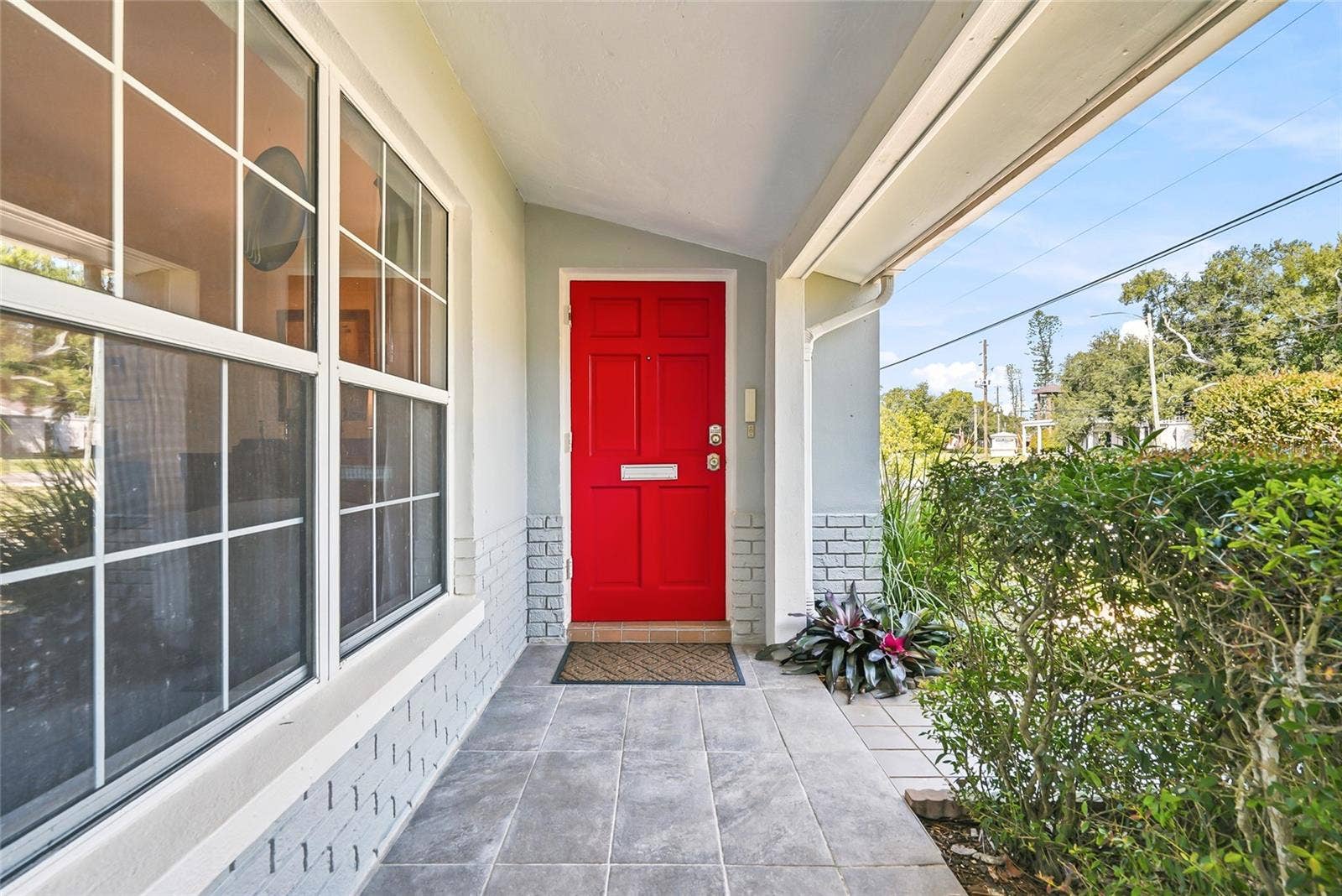 1890 62ND AVENUE S, St Petersburg, FL 33712 Step inside through a cheerful red front door, tucked beneath a covered, tiled porch framed by beautiful landscaping.