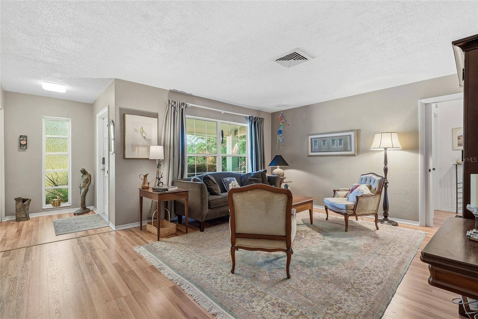 1890 62ND AVENUE S, St Petersburg, FL 33712 Natural light and garden views bring warmth to the front living room, creating an inviting setting for conversation or a quiet afternoon.