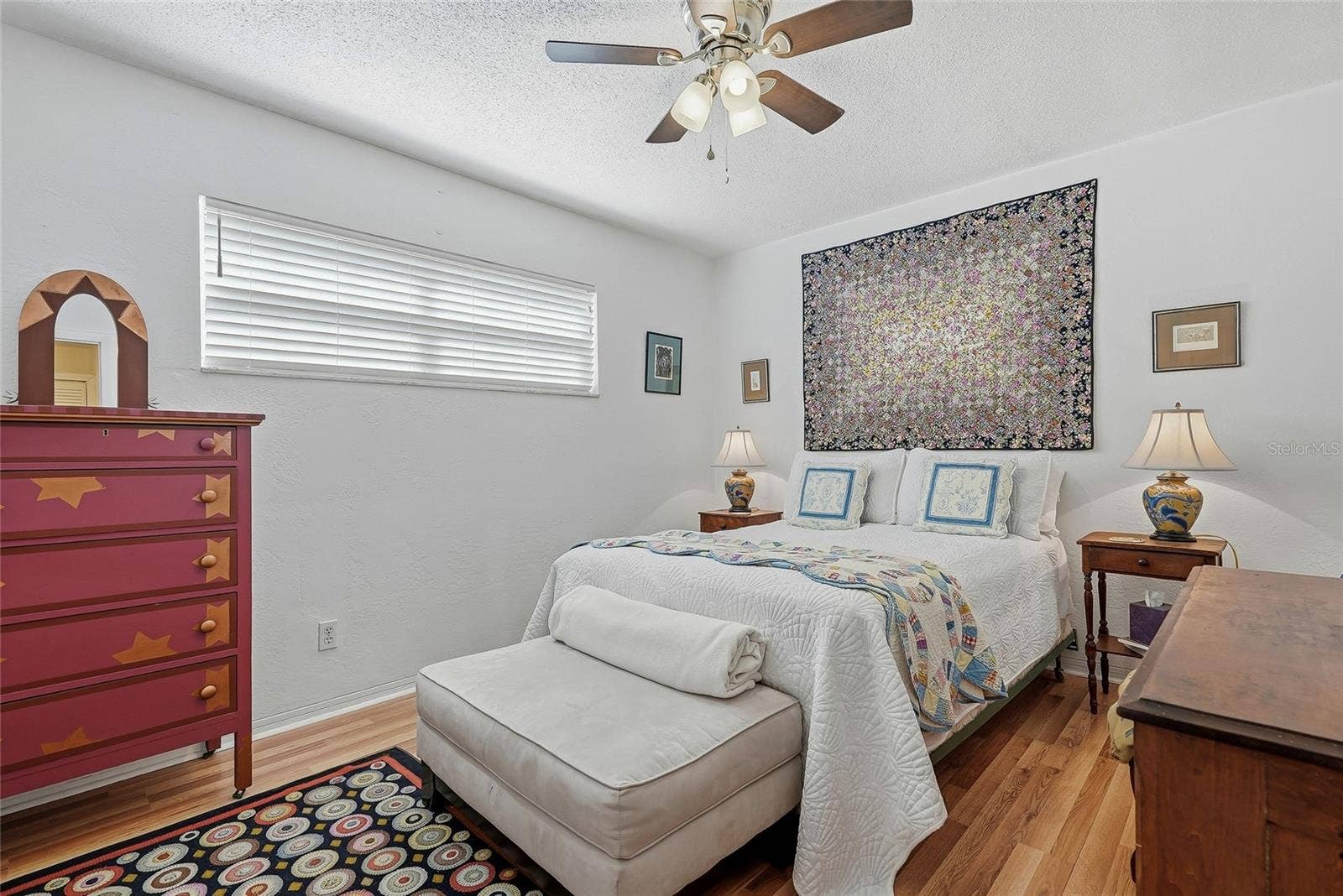 1890 62ND AVENUE S, St Petersburg, FL 33712 A welcoming second bedroom with soft neutral tones, warm wood-look flooring, and a wide window offers an inviting place to settle in.