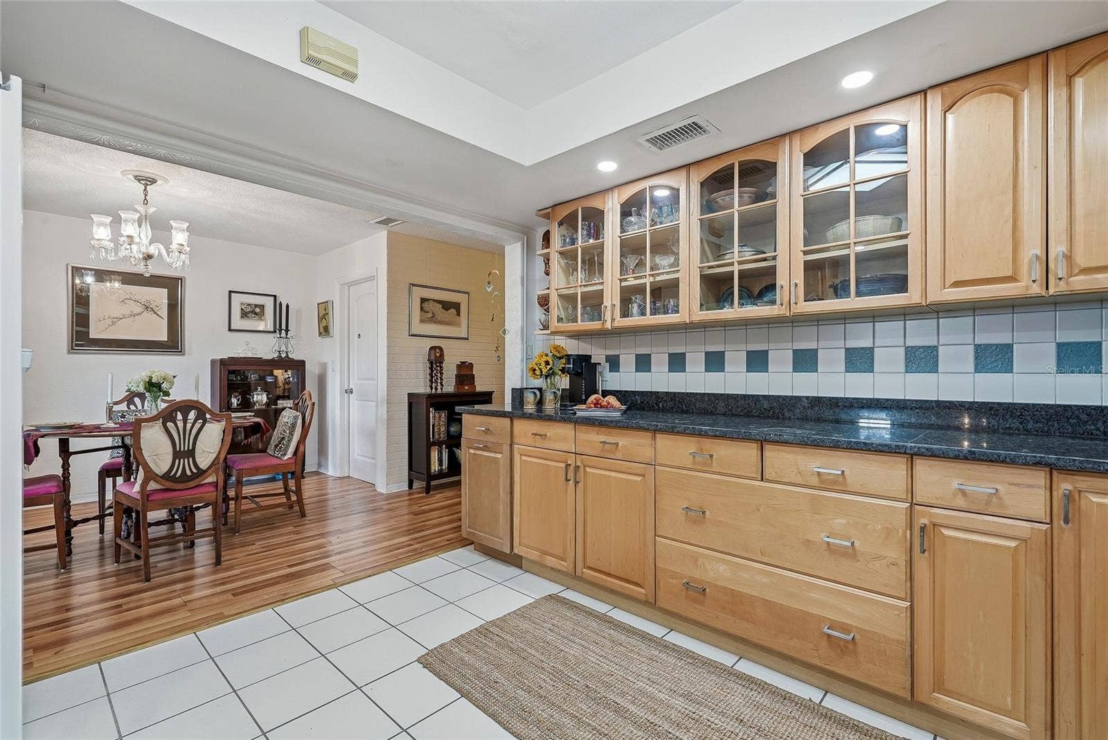 1890 62ND AVENUE S, St Petersburg, FL 33712 Glass-front cabinetry adds charm above an expansive counter, perfect for meal preparation or serving a spread just steps from the dining table.