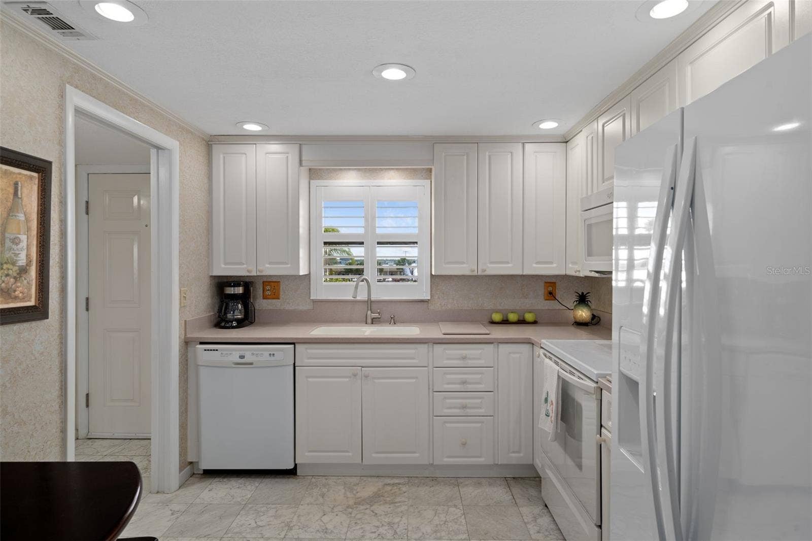 1230 GULF BOULEVARD, #303, Clearwater Beach, FL 33767 Open kitchen features Corian countertops, Whirlpool appliances and tile flooring