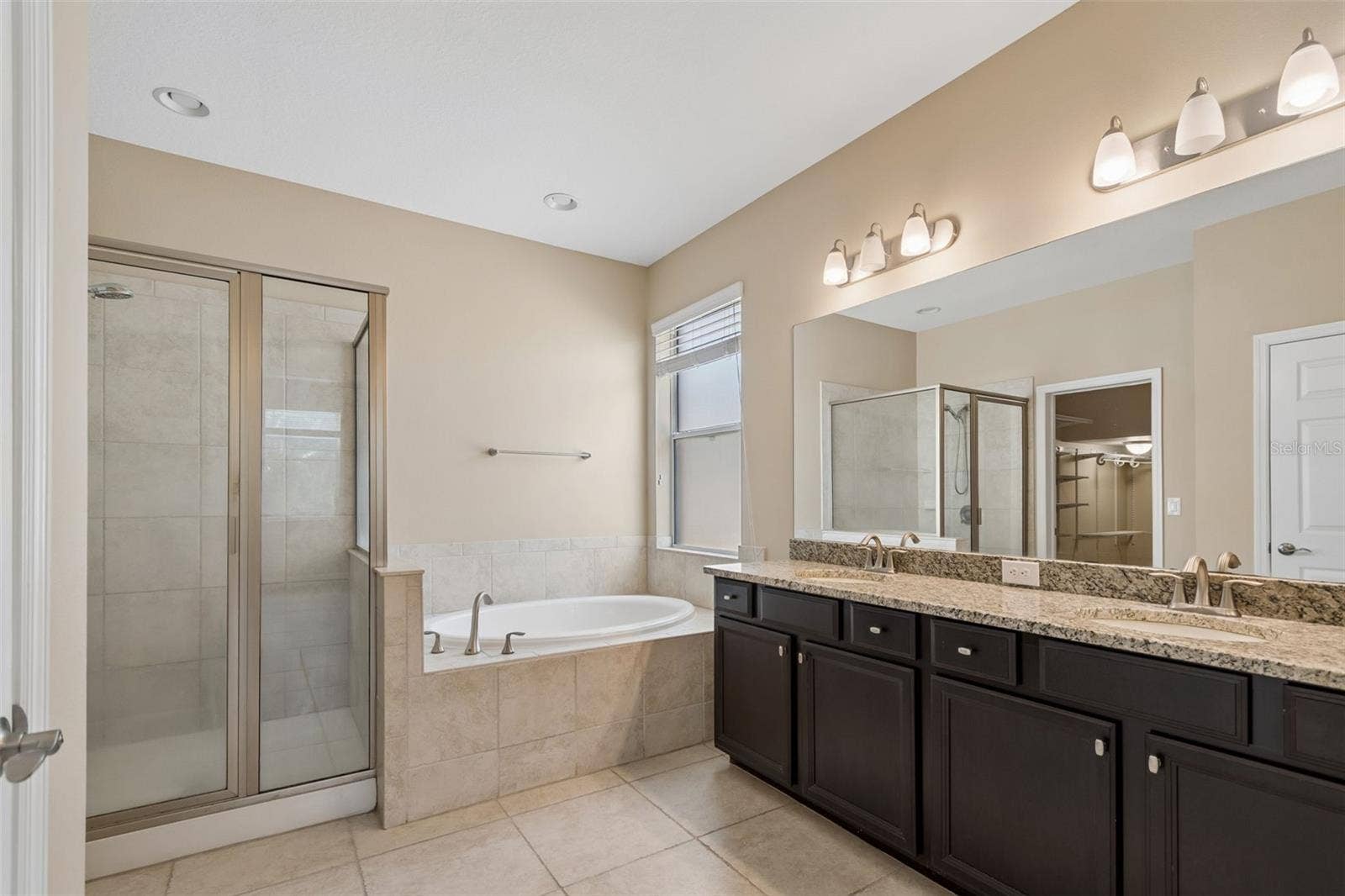 7090 88TH AVE N, Pinellas Park, FL 33782 Unwind in the luxurious primary bath, complete with dual sinks, a walk-in shower, and a garden tub designed for relaxation.