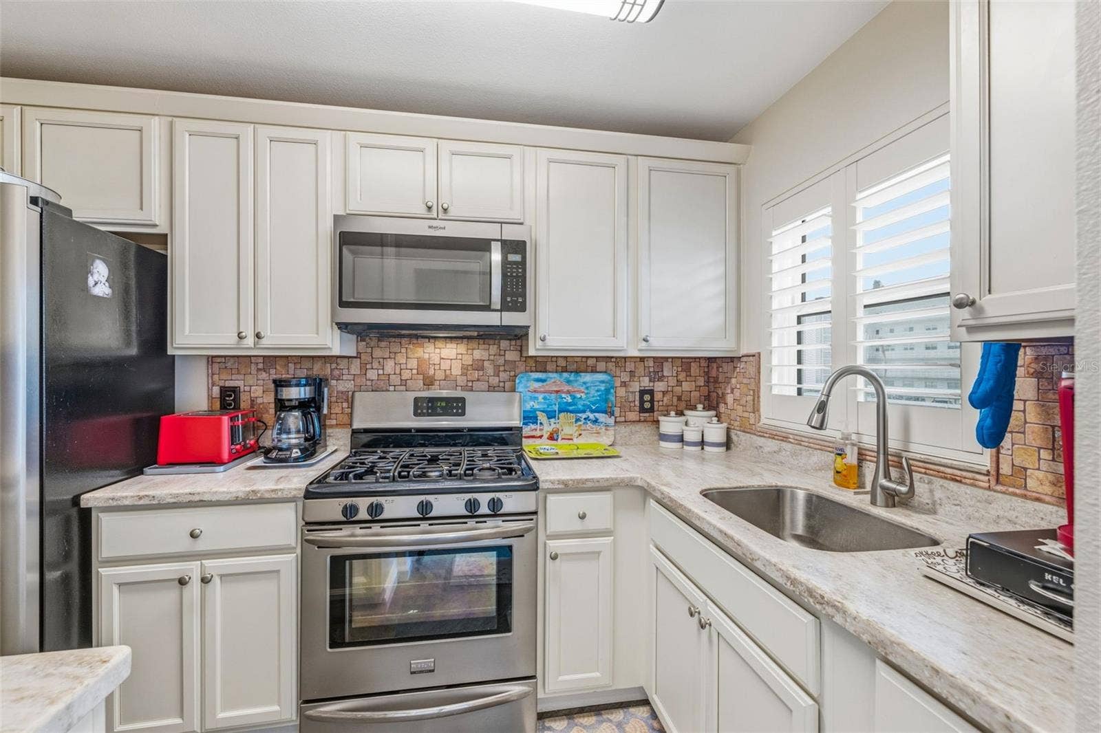 5521 80TH STREET N, #212, St Petersburg, FL 33709 Updated kitchen with white cabinetry