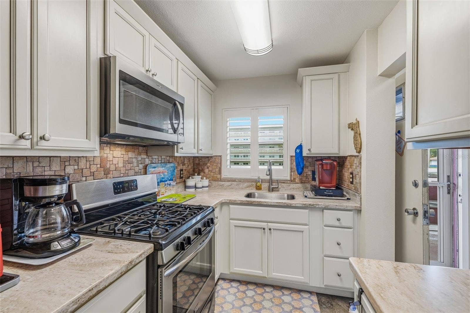 5521 80TH STREET N, #212, St Petersburg, FL 33709 Galley kitchen layout with bright lighting