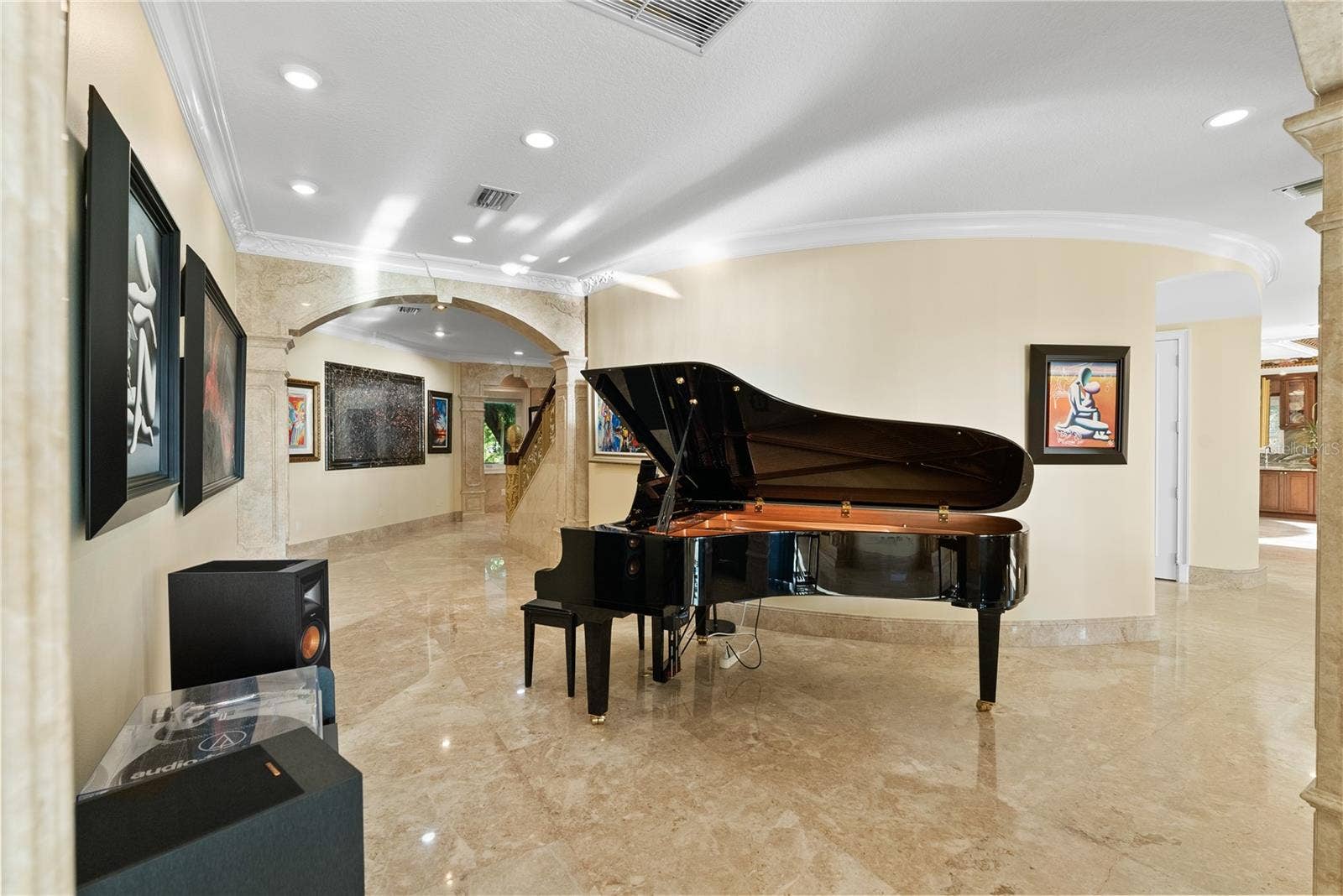 2000 PARK STREET N, St Petersburg, FL 33710 A refined art corridor where the grand piano becomes both centerpiece and statement, enhanced by a custom backlit stone installation that elevates the space with a gallery-style ambiance.