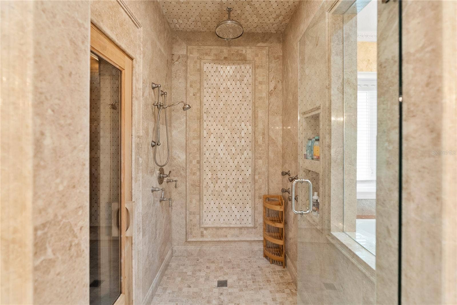2000 PARK STREET N, St Petersburg, FL 33710 The main-level primary suite serves as a private retreat, featuring a spa-inspired marble ensuite bath with Phylrich fixtures, a large sauna, soaking tub, multi-jet full-body rain shower, multiple vanities, and expansive custom closets
