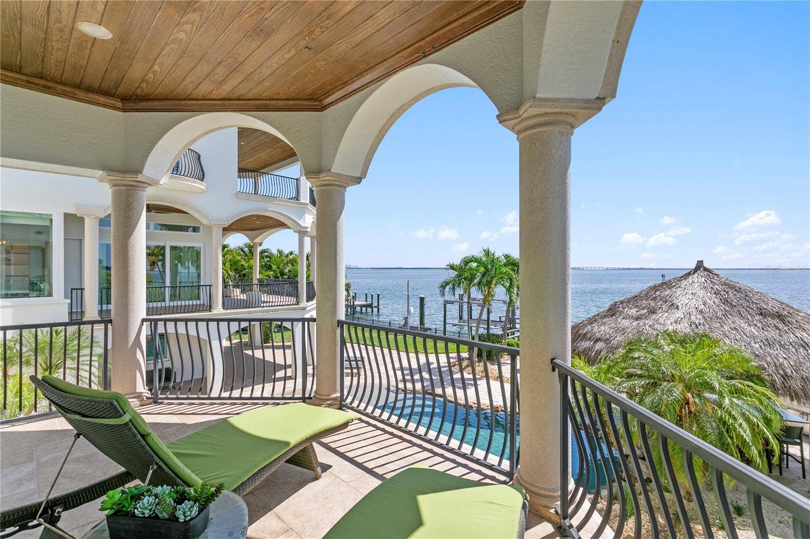 Private balcony off the main level primary suite, overlooking sparkling waters.