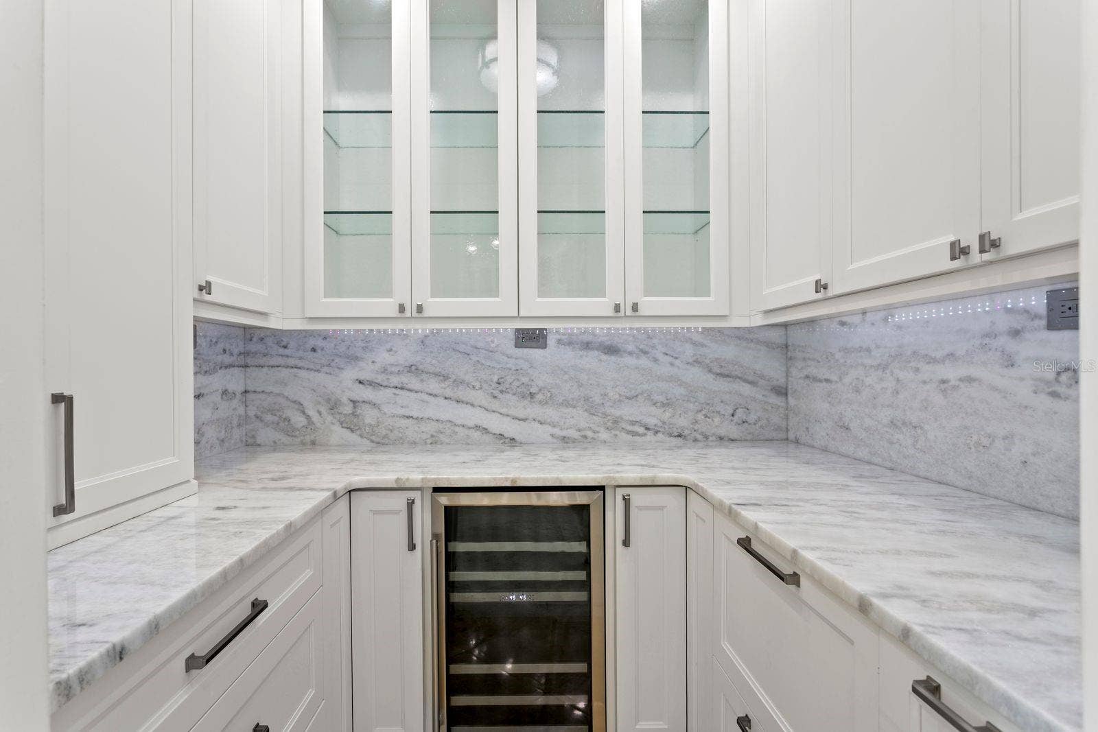 A sophisticated butler's pantry located just off the kitchen offers an expansive prep area for entertaining and includes a wine refrigerator.