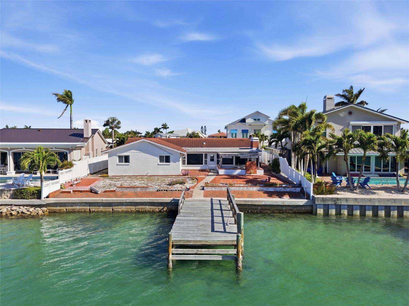 Drone photo of the back of 4 Bellevue looking north at the seawall, dock and rear of the home.