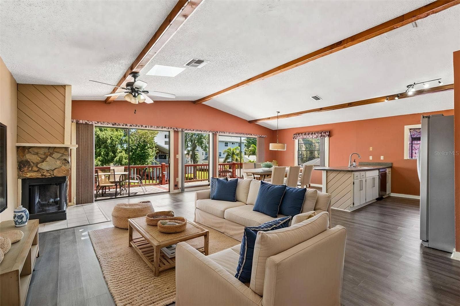 3141 N CANAL DRIVE, Palm Harbor, FL 34684 Fabulous open floor plan, with vaulted ceilings, decorative wood beams, skylight, luxury vinyl floors and fireplace.