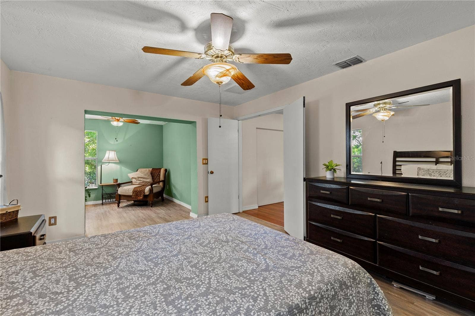Spacious primary bedroom retreat featuring a bright and airy layout with a comfortable sitting area, creating the perfect space for relaxation and privacy. The room offers abundant natural light and a peaceful atmosphere, ideal for an owners suite designed for comfort and everyday living.