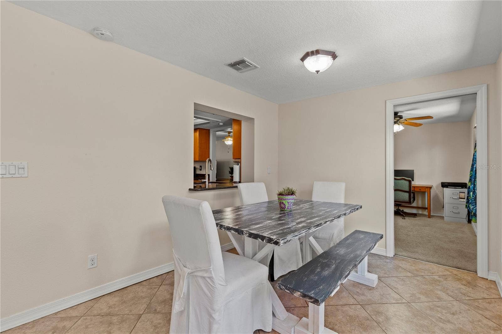 Bright Florida room offering flexible living space and convenient access to the fourth bedroom, making it ideal for use as a home office, guest suite, playroom, or private retreat. Natural light fills the space, creating a welcoming and versatile extension of the home