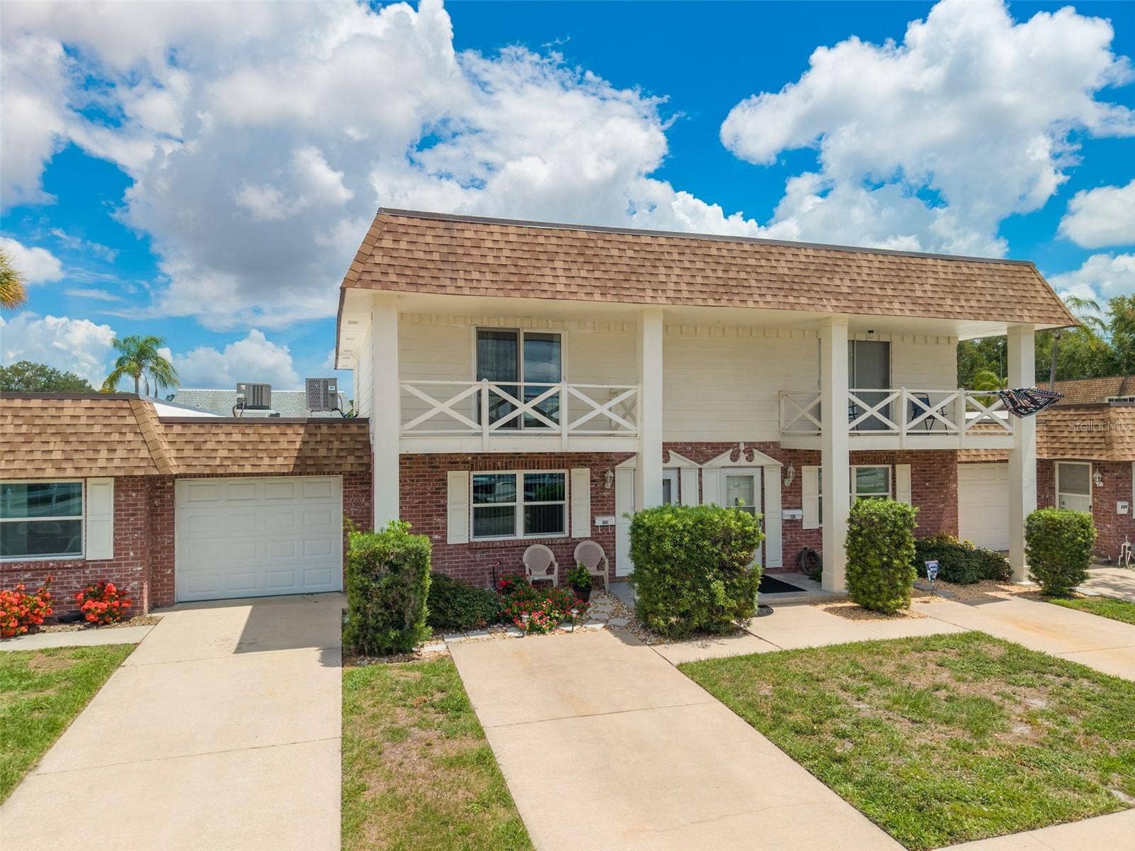 802 MINDY COURT, #802, Largo, FL 33771 Beautiful brick-clad townhome-style condo with front outdoor porch and upper balcony.