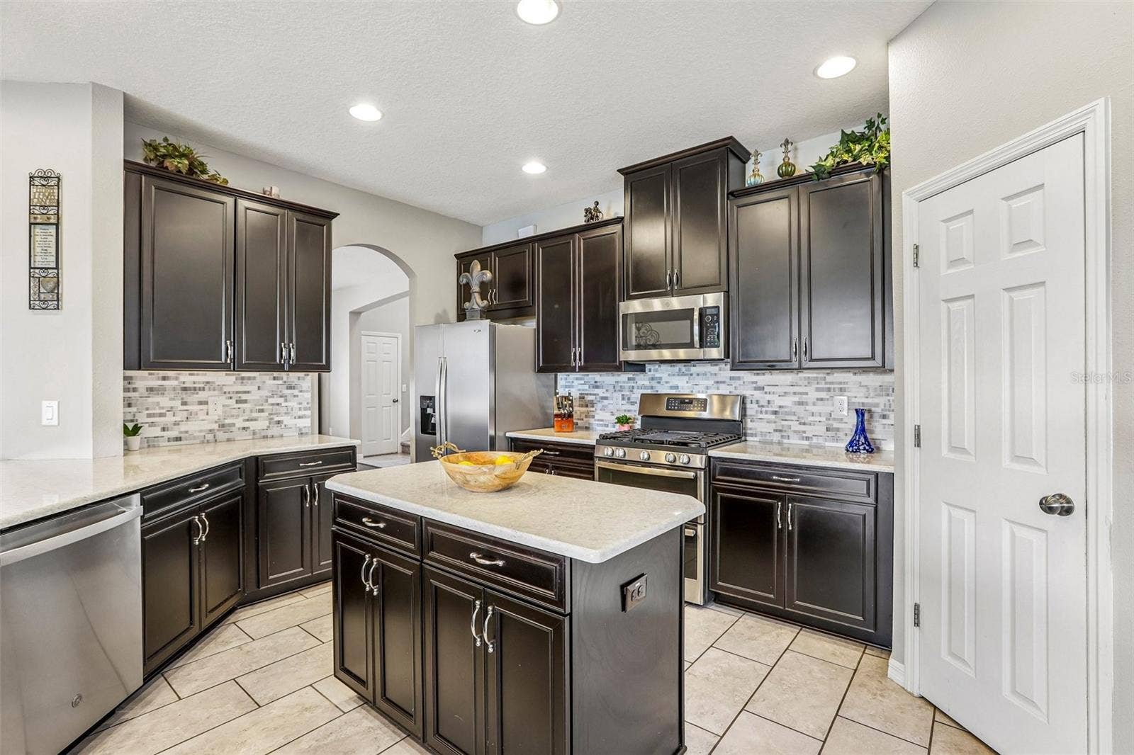 17628 BRIGHT WHEAT DRIVE, Lithia, FL 33547 Kitchen area with 42" cabinets, stained appliances, gas range, beautiful backsplash, Island and quartz