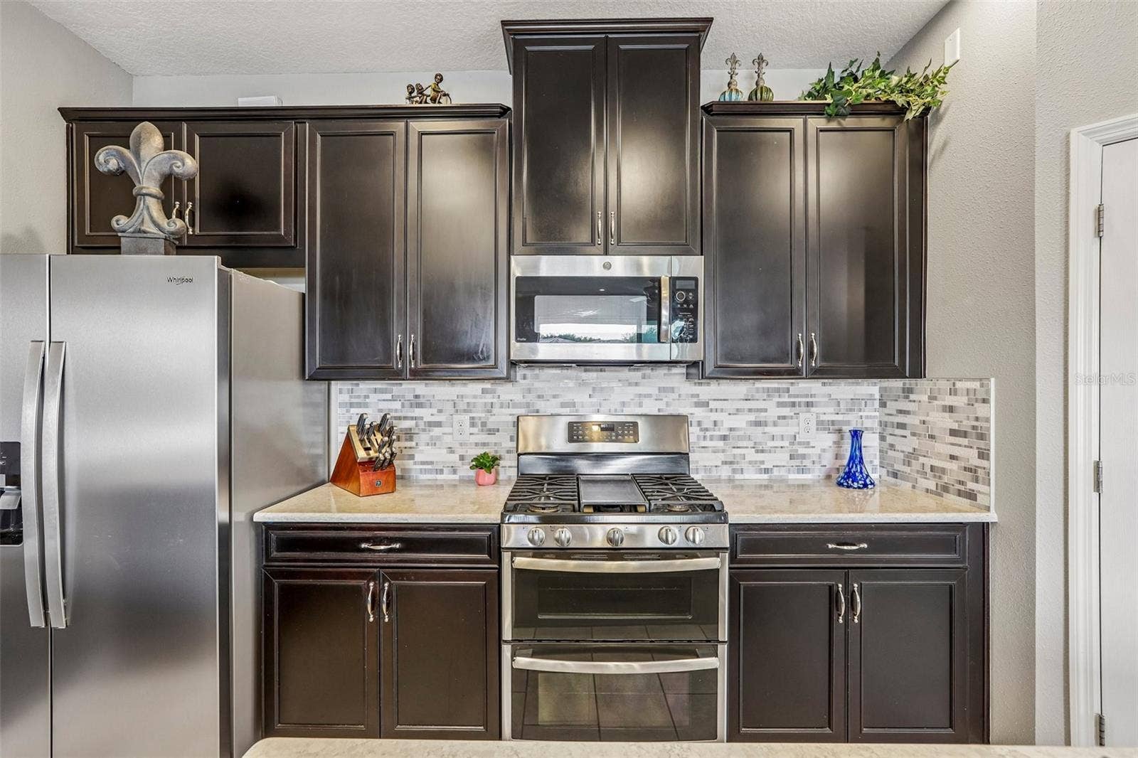 17628 BRIGHT WHEAT DRIVE, Lithia, FL 33547 Kitchen area with 42" cabinets, stained appliances, gas range, beautiful backsplash, Island and quartz