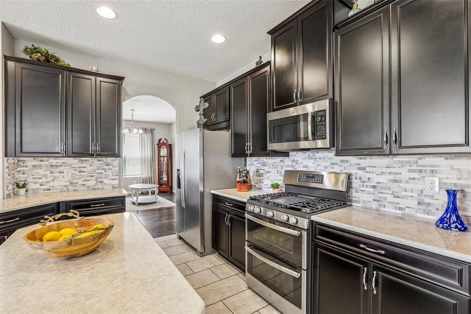 17628 BRIGHT WHEAT DRIVE, Lithia, FL 33547 Kitchen area with 42" cabinets, stained appliances, gas range, beautiful backsplash, Island and quartz
