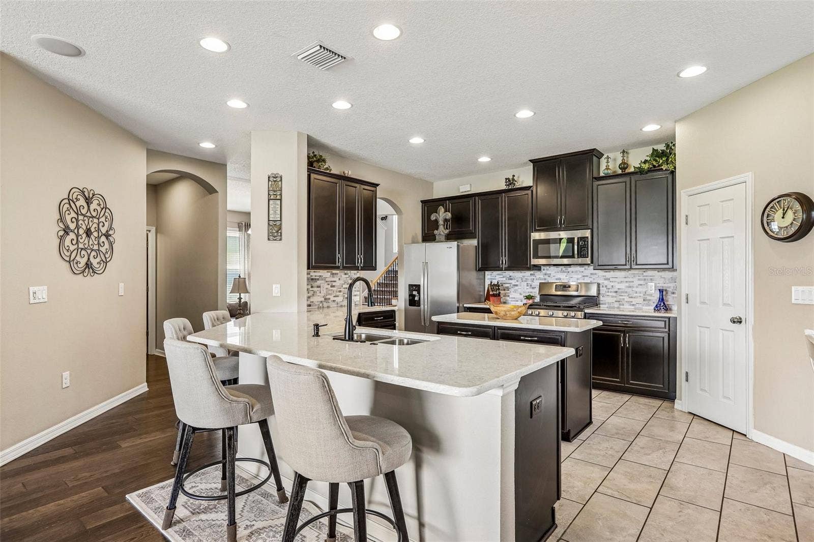 17628 BRIGHT WHEAT DRIVE, Lithia, FL 33547 Kitchen area with 42" cabinets, stained appliances, gas range, beautiful backsplash, Island and quartz