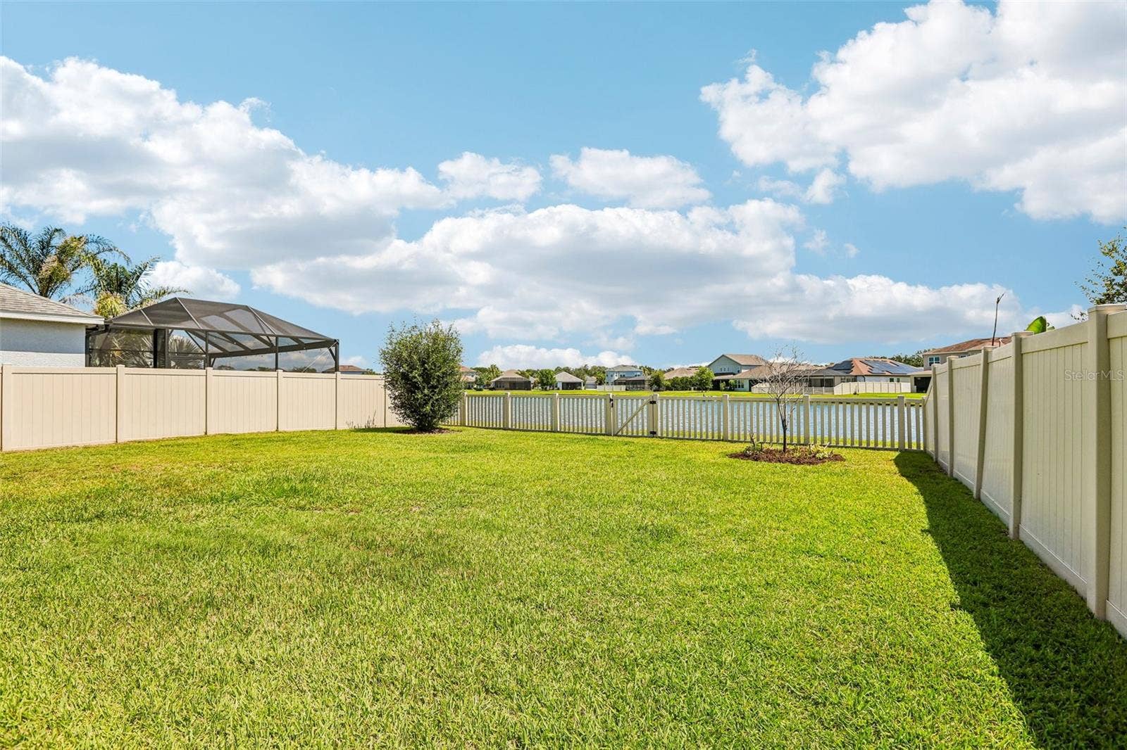 17628 BRIGHT WHEAT DRIVE, Lithia, FL 33547 Back yard with vinyl fencing and view to pond