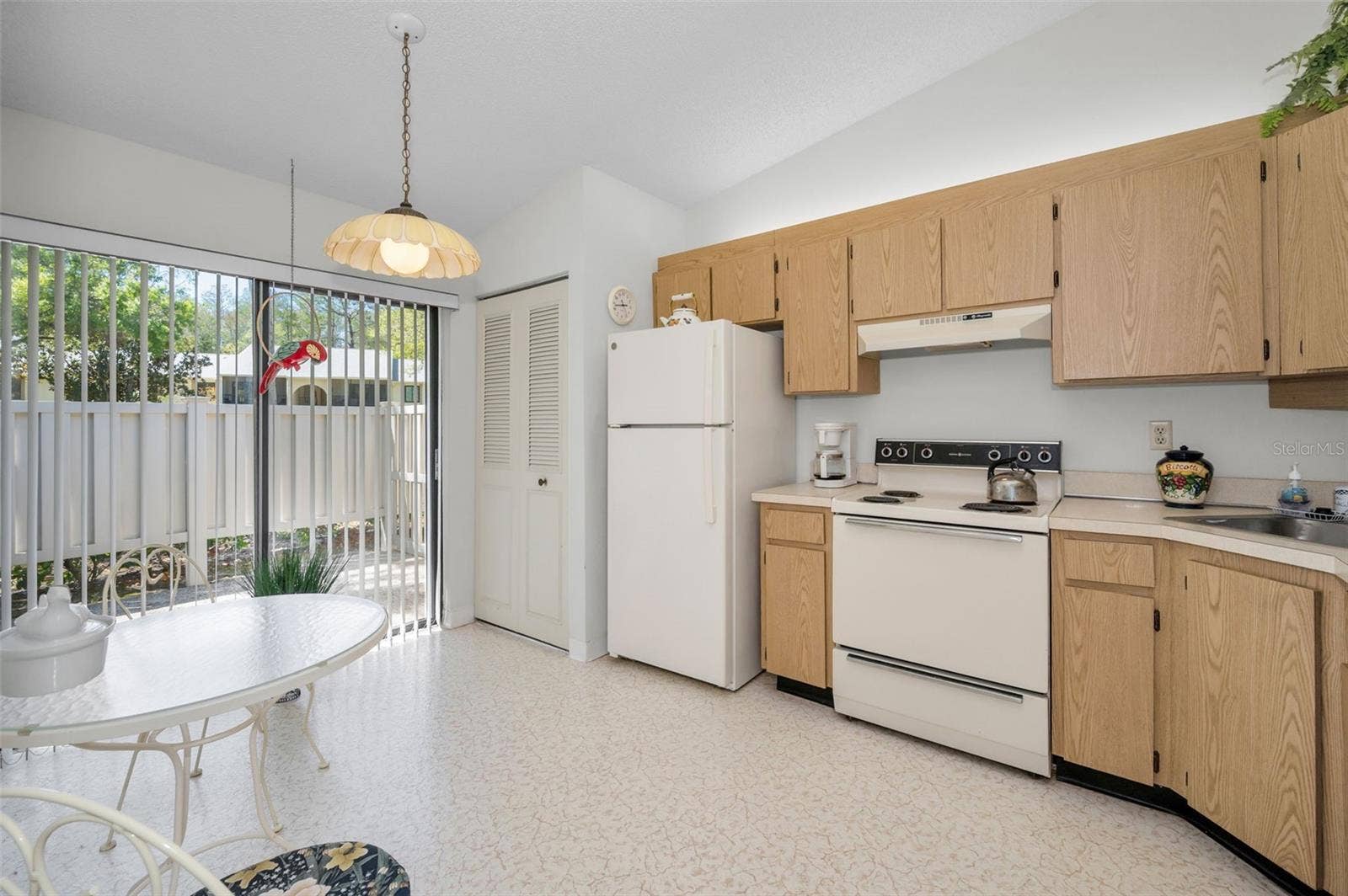 1333 SHADY PINE WAY, #F, Tarpon Springs, FL 34688 Kitchen With Laundry Closet, Eating Space, and Slider To The Front Patio
