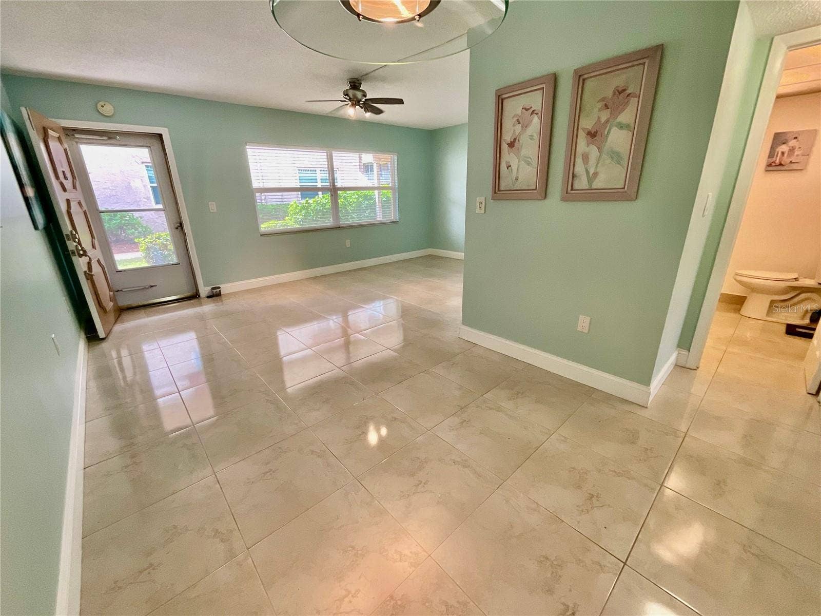 10034 64TH AVENUE N, #11, St Petersburg, FL 33708 Living/Dining room with door to greenspace and covered, reserved parking spot