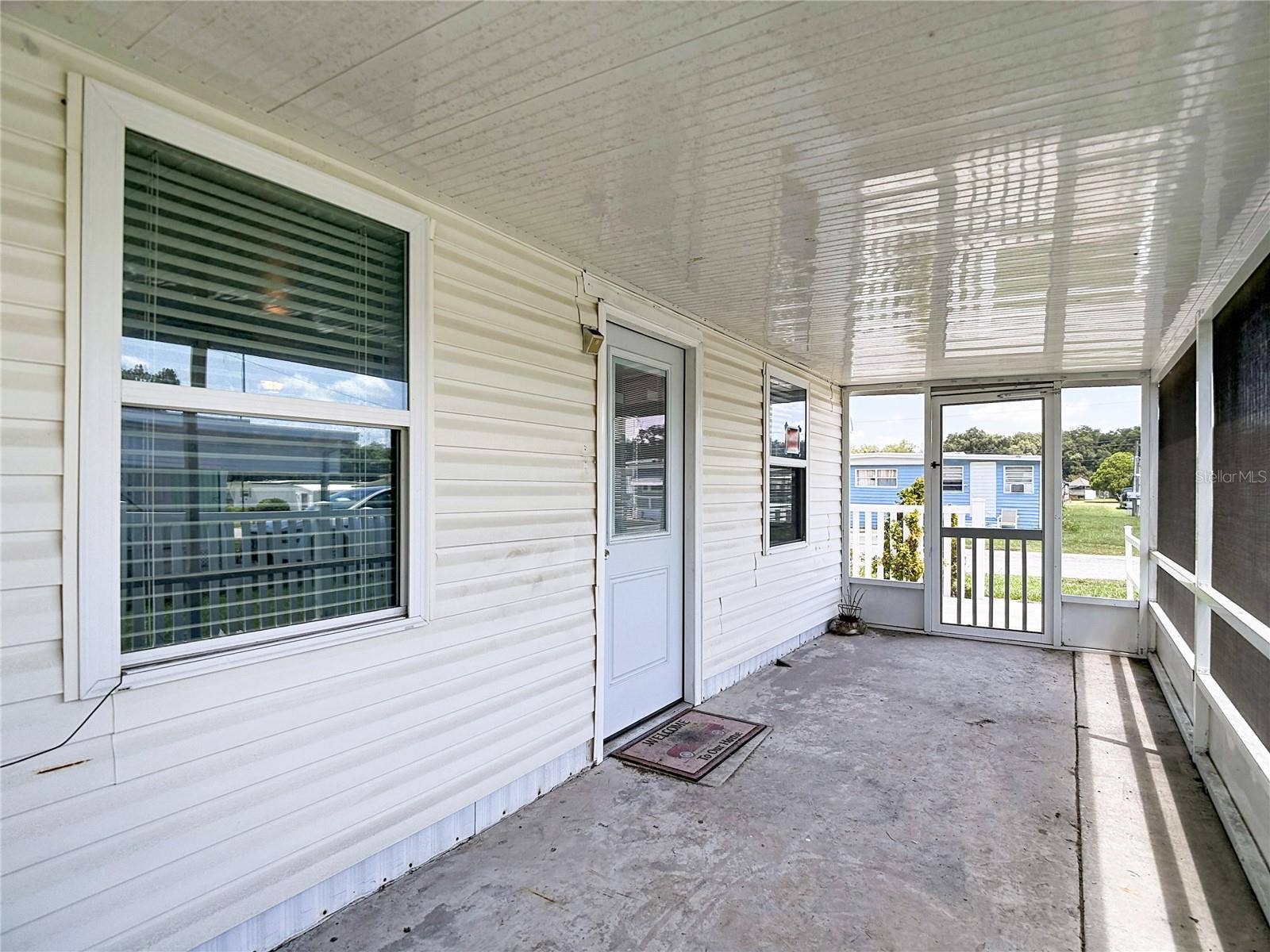 39032 OLA AVENUE, Zephyrhills, FL 33542 Front screened porch. One side has a lockable doggie door