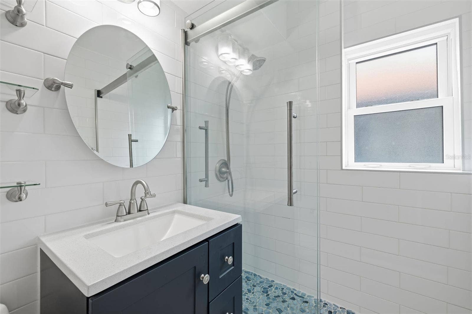 841 4TH AVENUE N, #27, St Petersburg, FL 33701 Updated vanity, contemporary fixtures, and a bright window complete the refreshed bathroom.