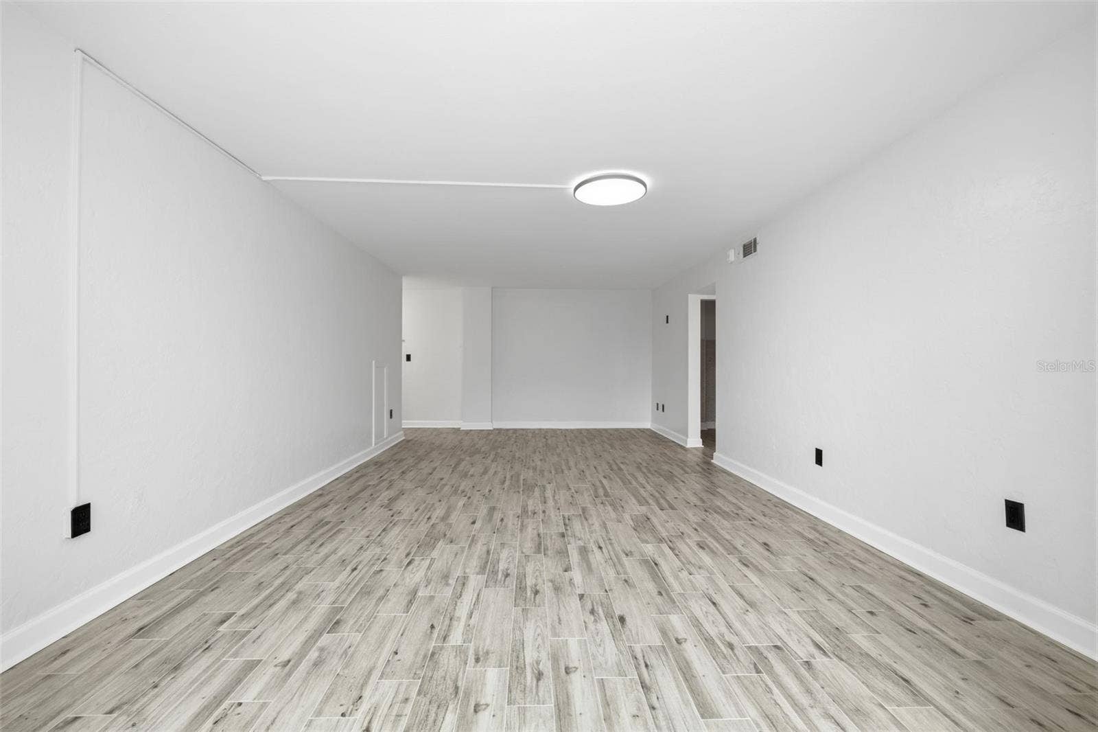 841 4TH AVENUE N, #27, St Petersburg, FL 33701 Spacious living area with fresh paint, new tile flooring, and a long, open layout offering plenty of flexibility for comfortable seating and entertaining.