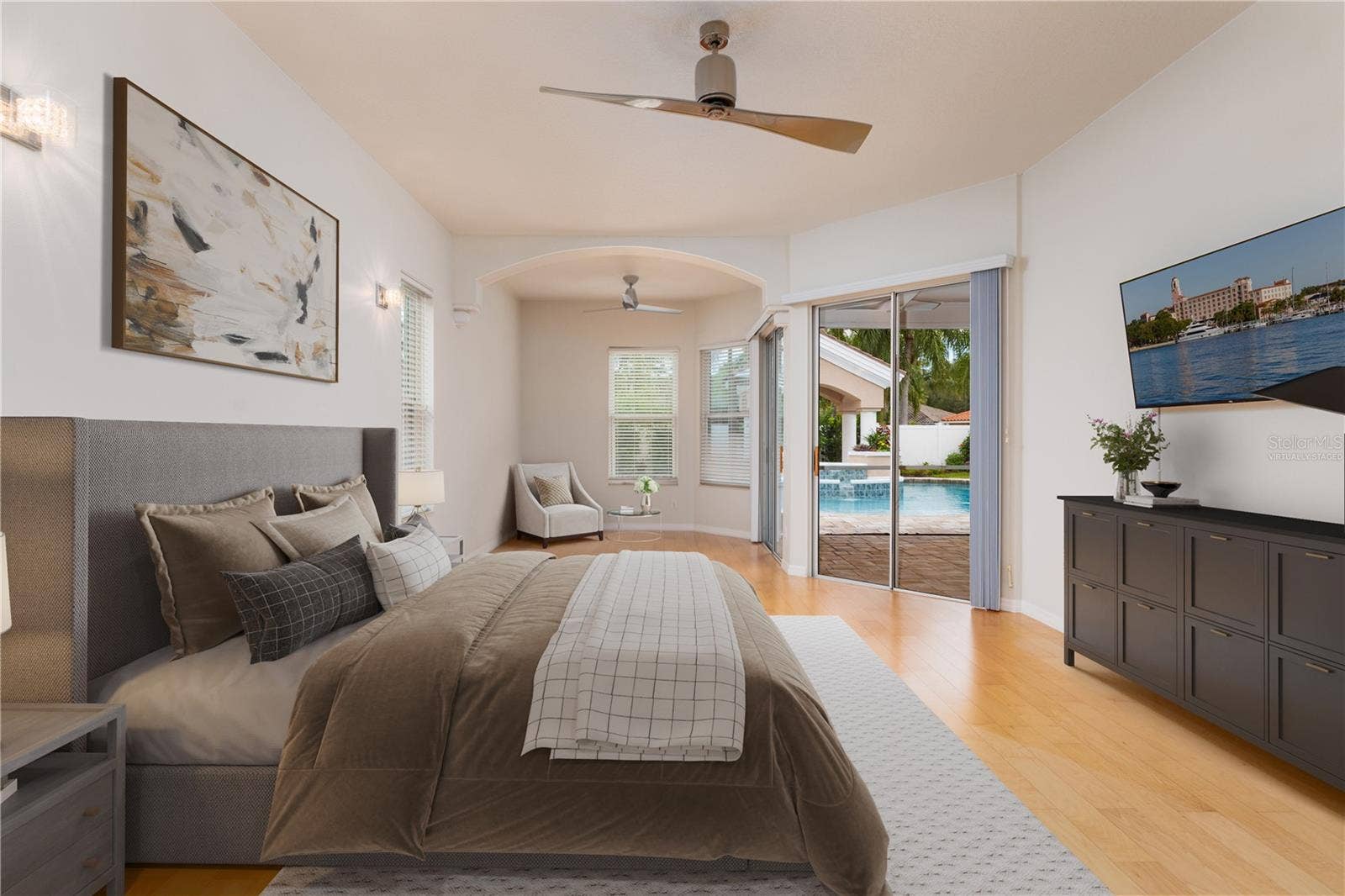 Virtually staged pirmary bedroom with siting area.  Sliders to screened porch & pool area.