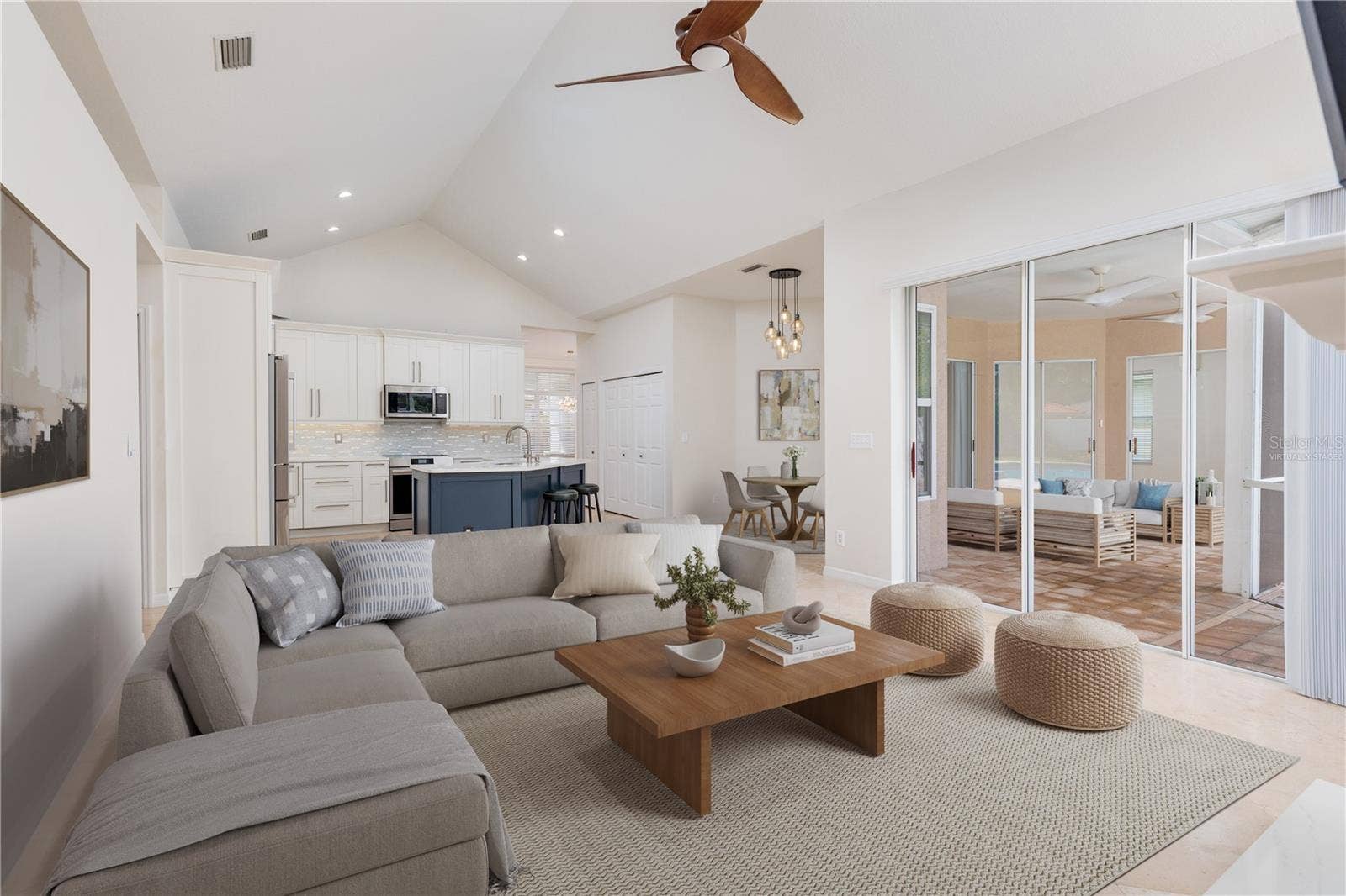 Virtually staged family toom with sliders opening to screened porch & pool area