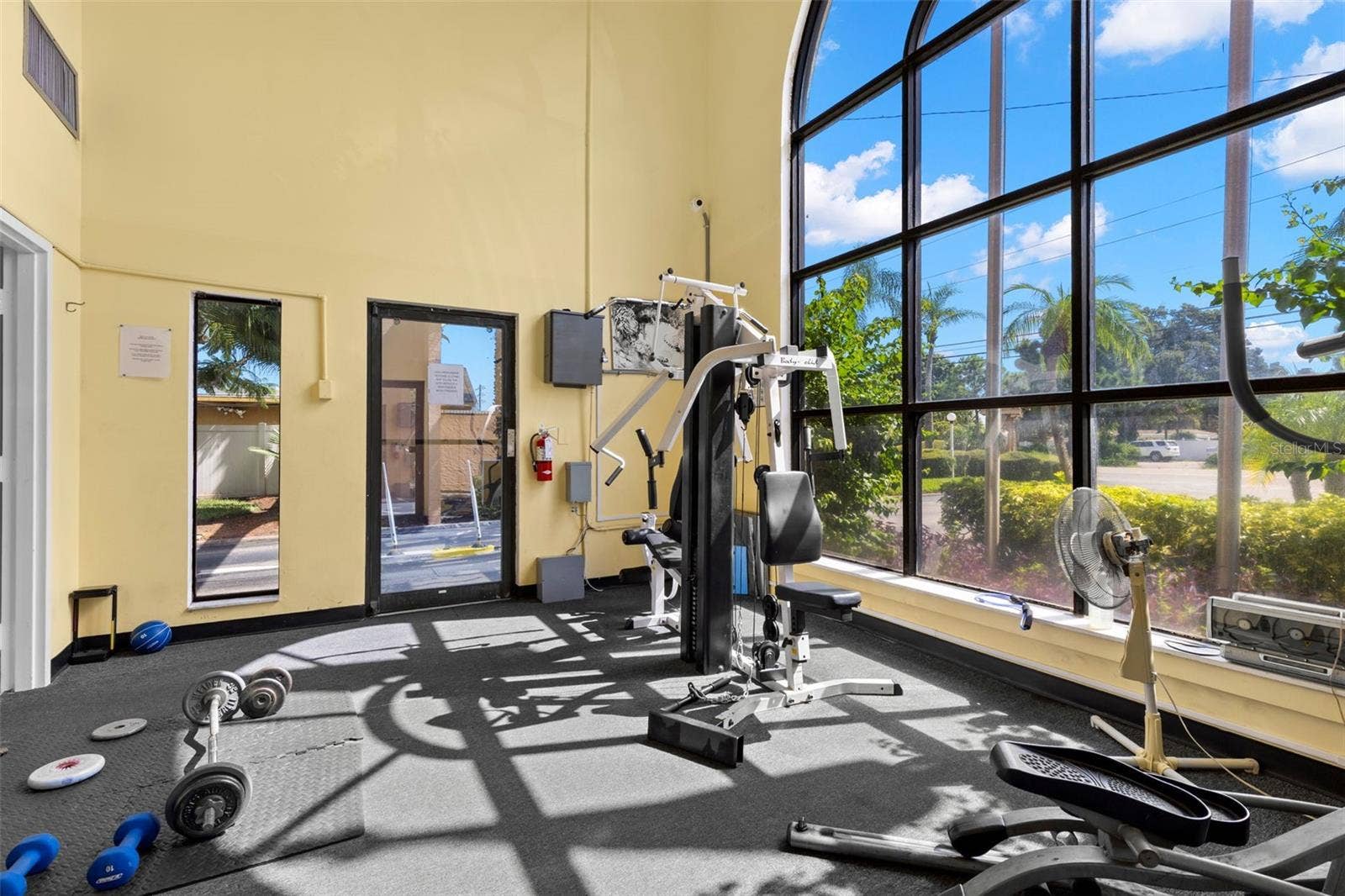 12760 INDIAN ROCKS ROAD, #107, Largo, FL 33774 Tall arched windows fill the fitness center with natural light, while open floor space and a mix of strength-training equipment add flexibility to the community workout area.