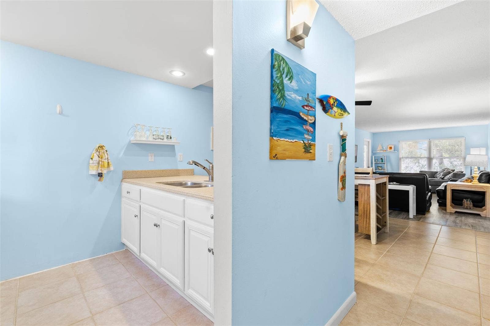 12760 INDIAN ROCKS ROAD, #107, Largo, FL 33774 Just inside the entry, the kitchen opens toward the dining and living areas, creating a natural connection through the main living space, with tile flooring, light cabinetry and a double-basin sink.