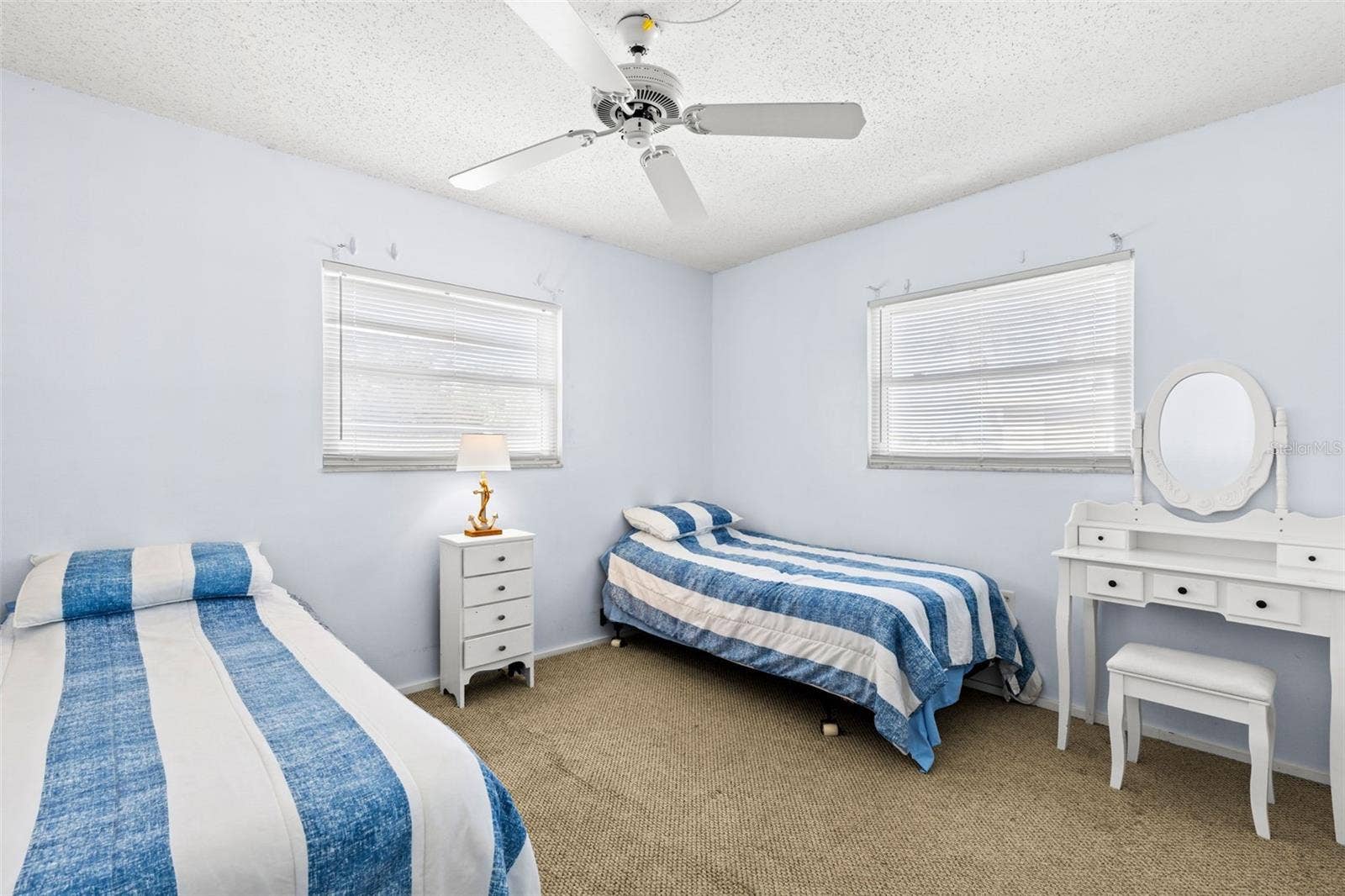 12760 INDIAN ROCKS ROAD, #107, Largo, FL 33774 Bedroom 2 measures approximately 10'5" x 11'3", with neutral carpet, a ceiling fan and windows on two walls bringing in plenty of natural light.