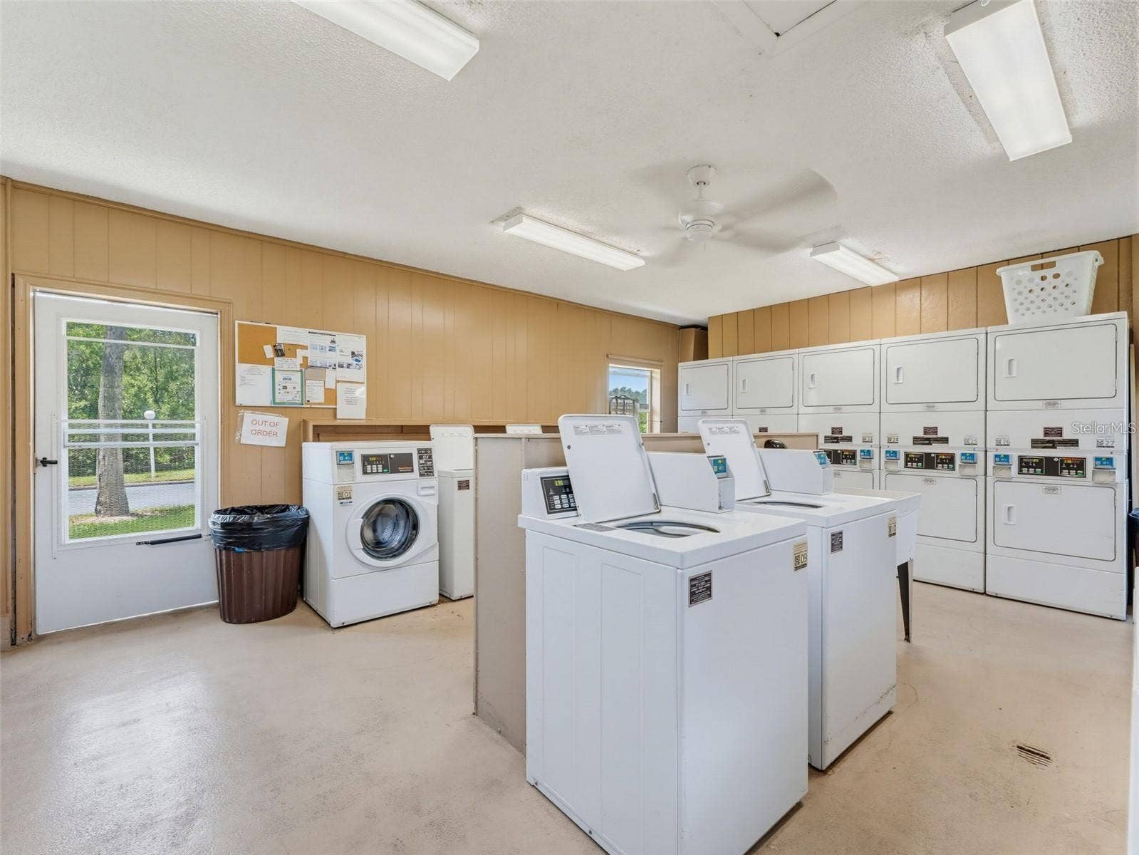12760 INDIAN ROCKS ROAD, #107, Largo, FL 33774 The community laundry room is equipped with multiple washers and dryers, providing a convenient shared option for residents within New Atlantis Club.