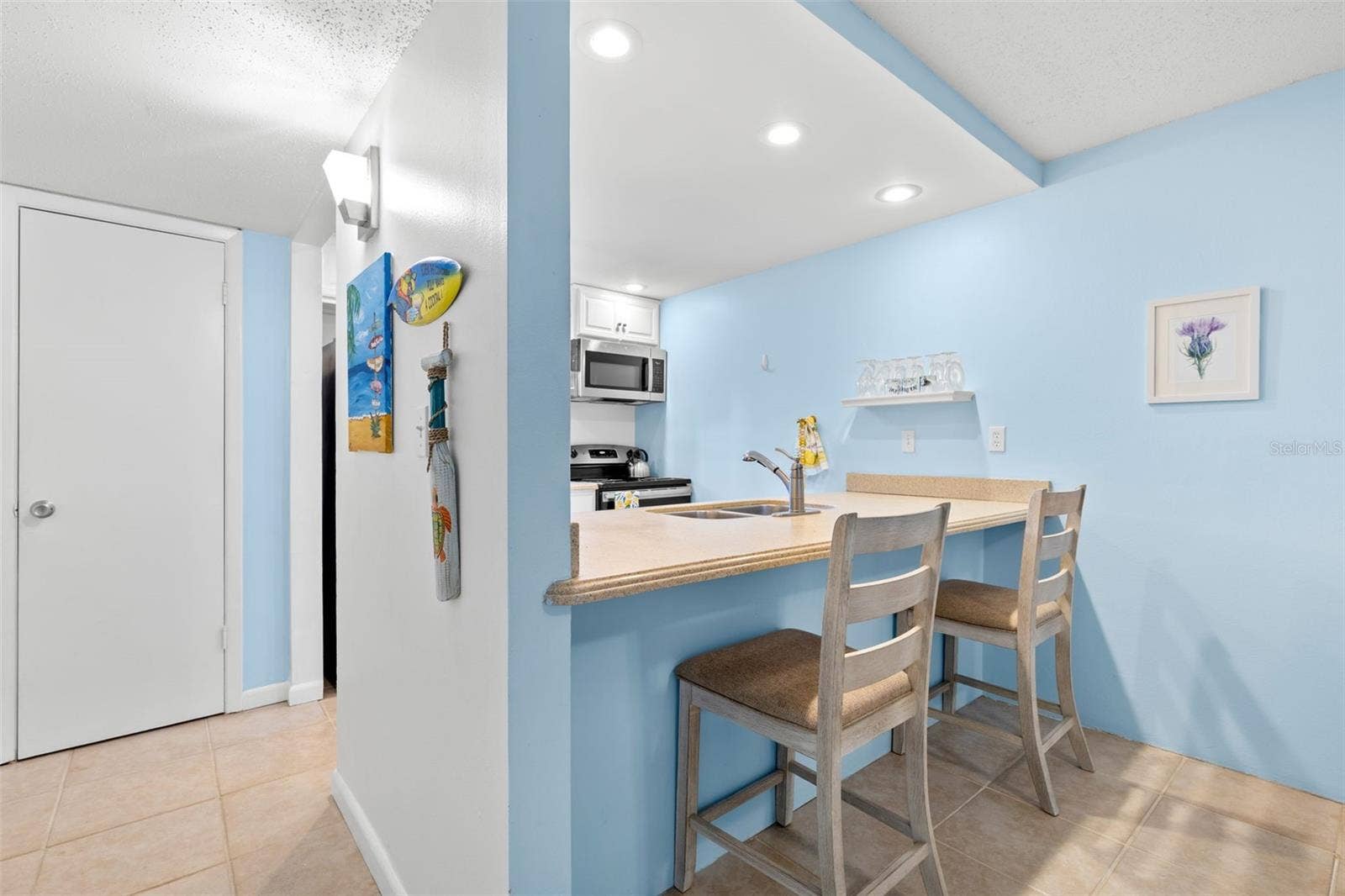 12760 INDIAN ROCKS ROAD, #107, Largo, FL 33774 A closer look from the dining area shows the breakfast bar with seating for two, while the kitchens recessed lighting, Corian counters and open pass-through keep the space bright and connected to the rest of the condo.