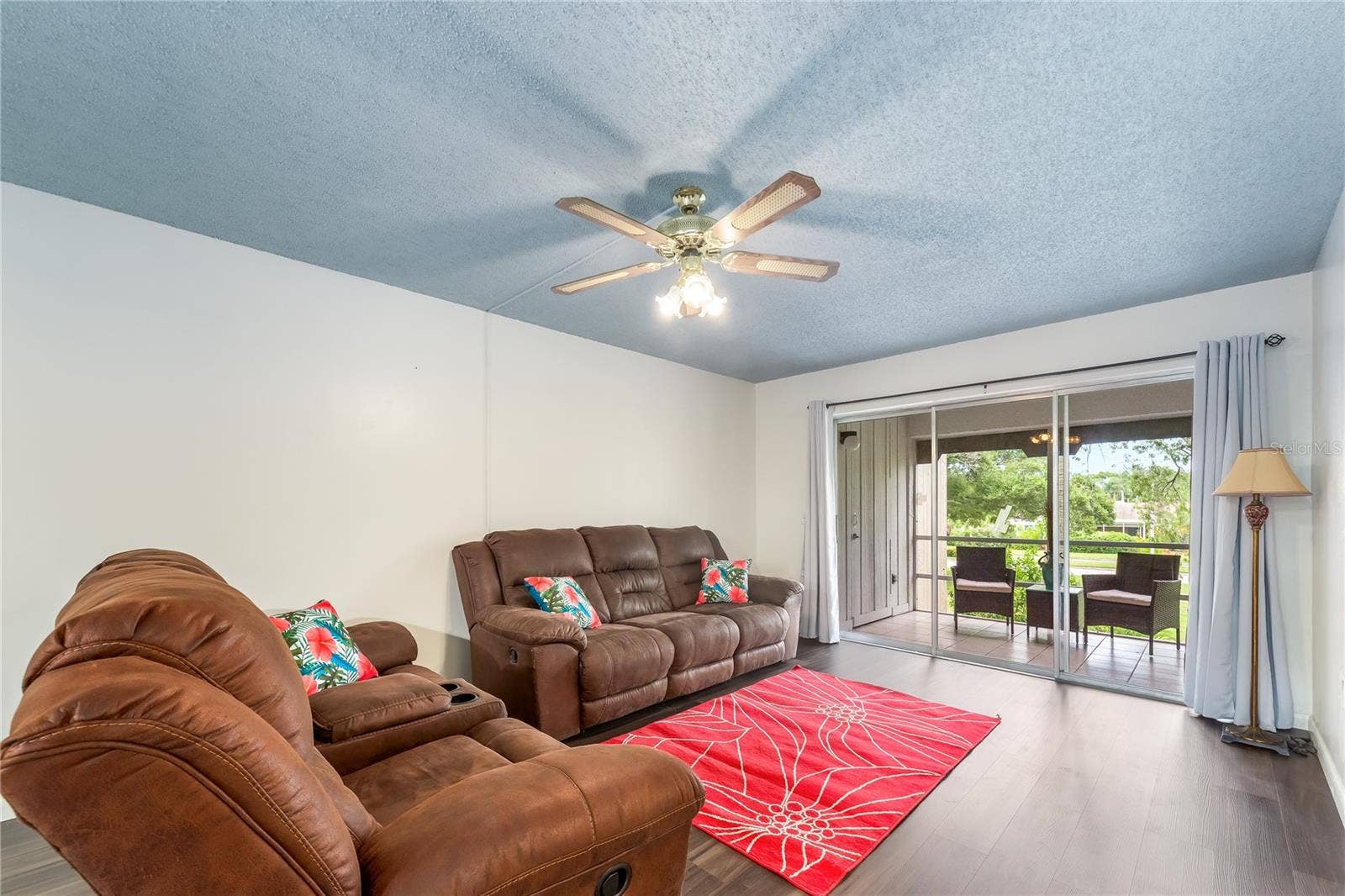 A living room with a view of mature Florida trees