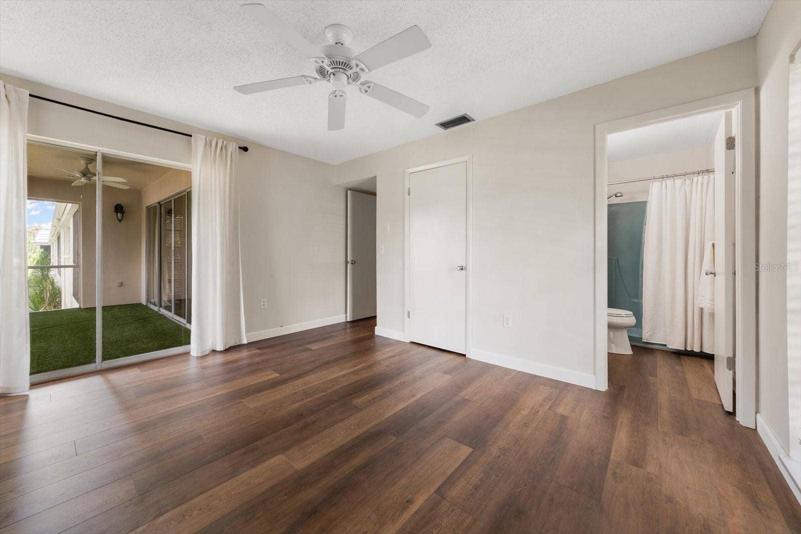 1975 W BAY DRIVE, #109, Largo, FL 33770 Primary bedroom with en suite bathroom, walk in closet with laundry, sliding glass doors to screened lanai