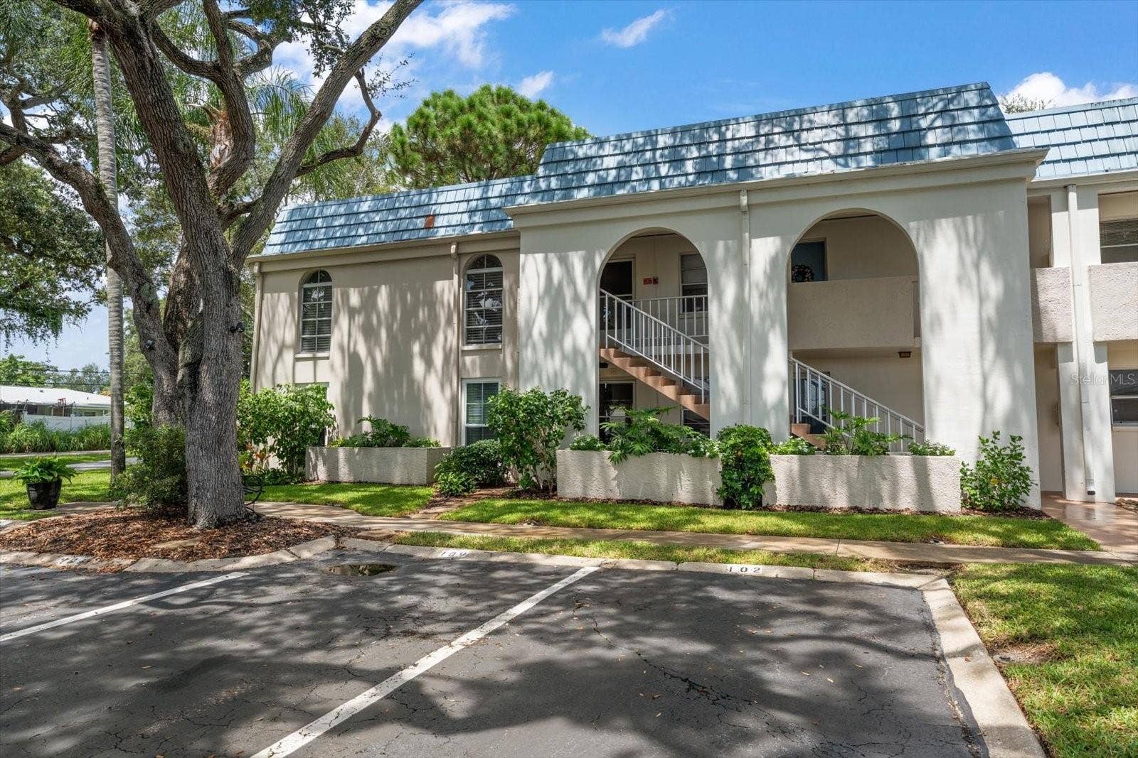 1975 W BAY DRIVE, #109, Largo, FL 33770 Front of building, unit is end unit on 2nd floor. Assigned parking space. Lush landscaping and oak trees