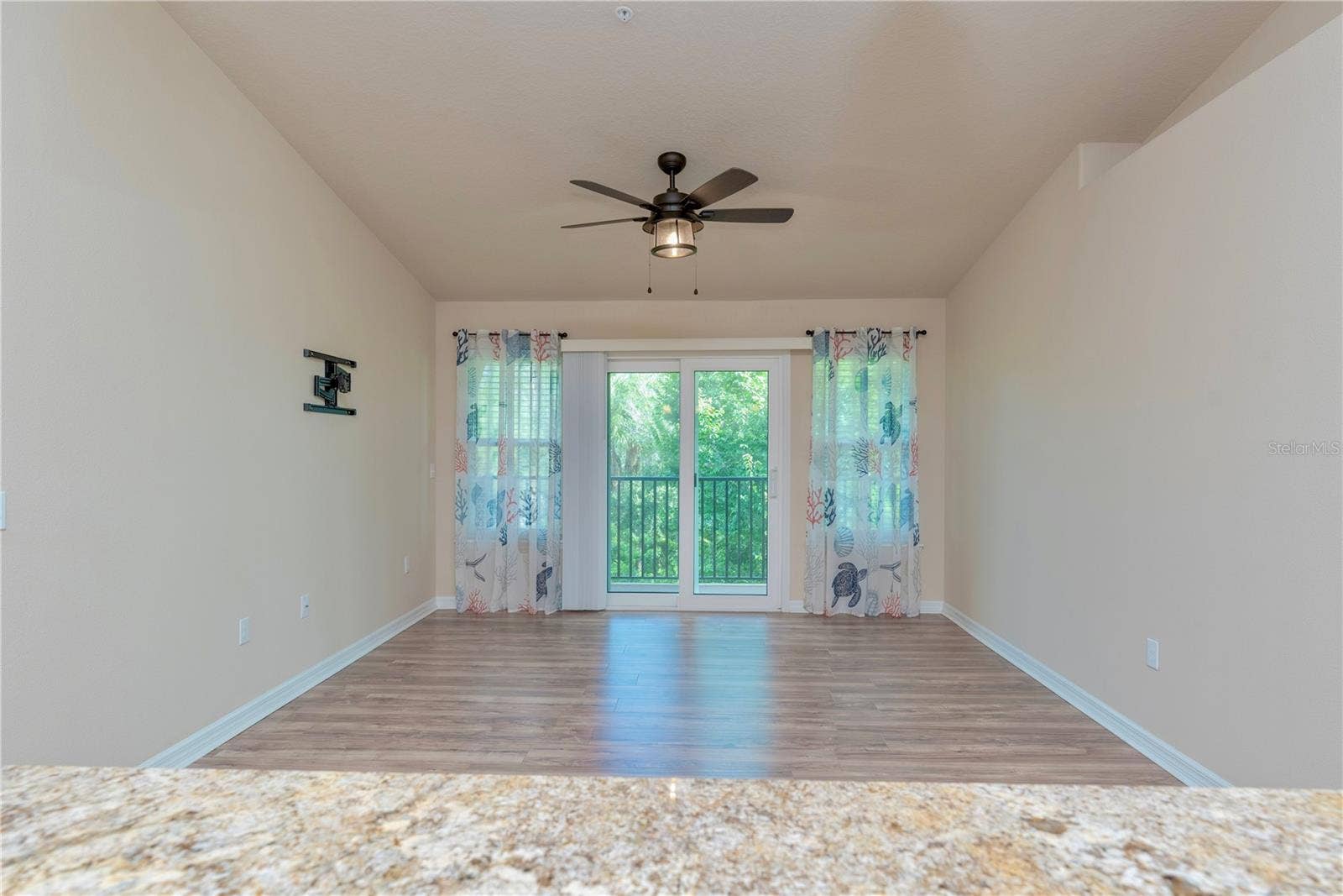 5065 ROYAL PALMS WAY, #303, New Port Richey, FL 34652 French doors leading to the covered balcony with view of trees.
