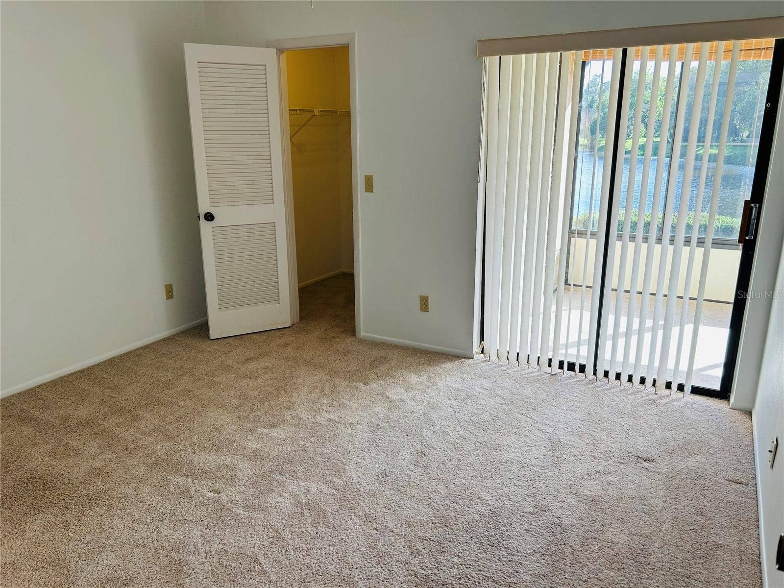 60 KAY COURT, Oldsmar, FL 34677 Second bedroom with walk in closet and sliders out to the screened in patio