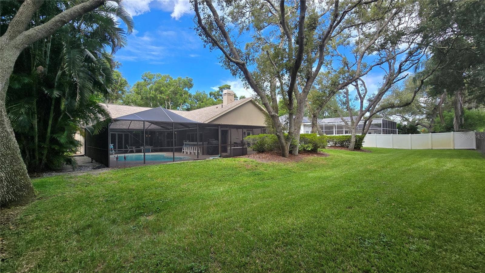 9991 WINDTREE BOULEVARD, Seminole, FL 33772 View of the pool area and the back yard.