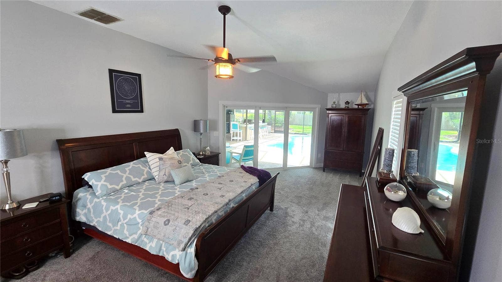 9991 WINDTREE BOULEVARD, Seminole, FL 33772 This primary suite bedroom has its own personal access through the sliding glass doors to enter the pool area. Size of bedroom is approximately 26 x 13 not including the 2 walk-in closets.