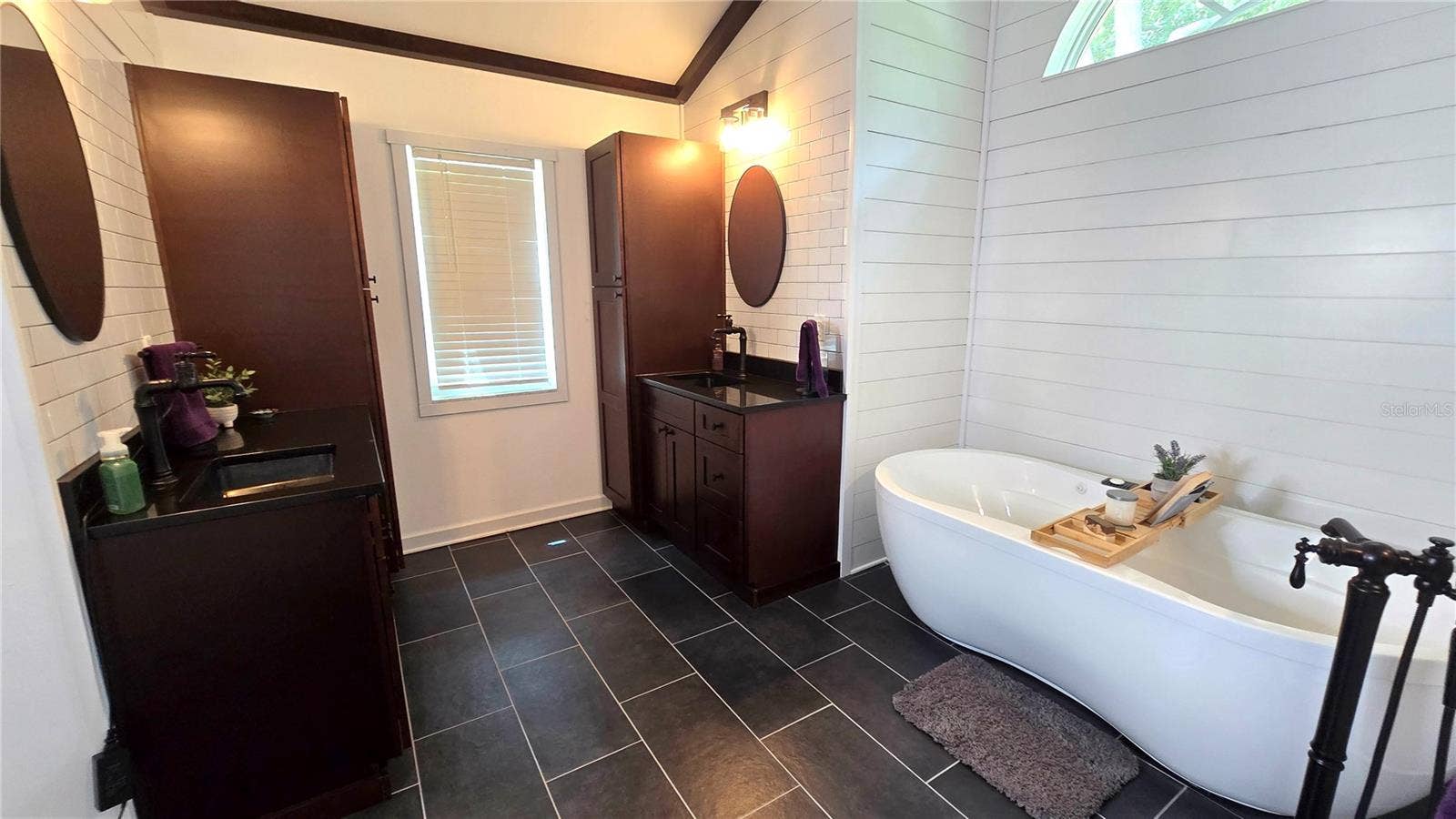 9991 WINDTREE BOULEVARD, Seminole, FL 33772 Primary Bathroom with 2 cabinets/vanity. Don't overlook this adorable tub to relax in after a hard day at work.