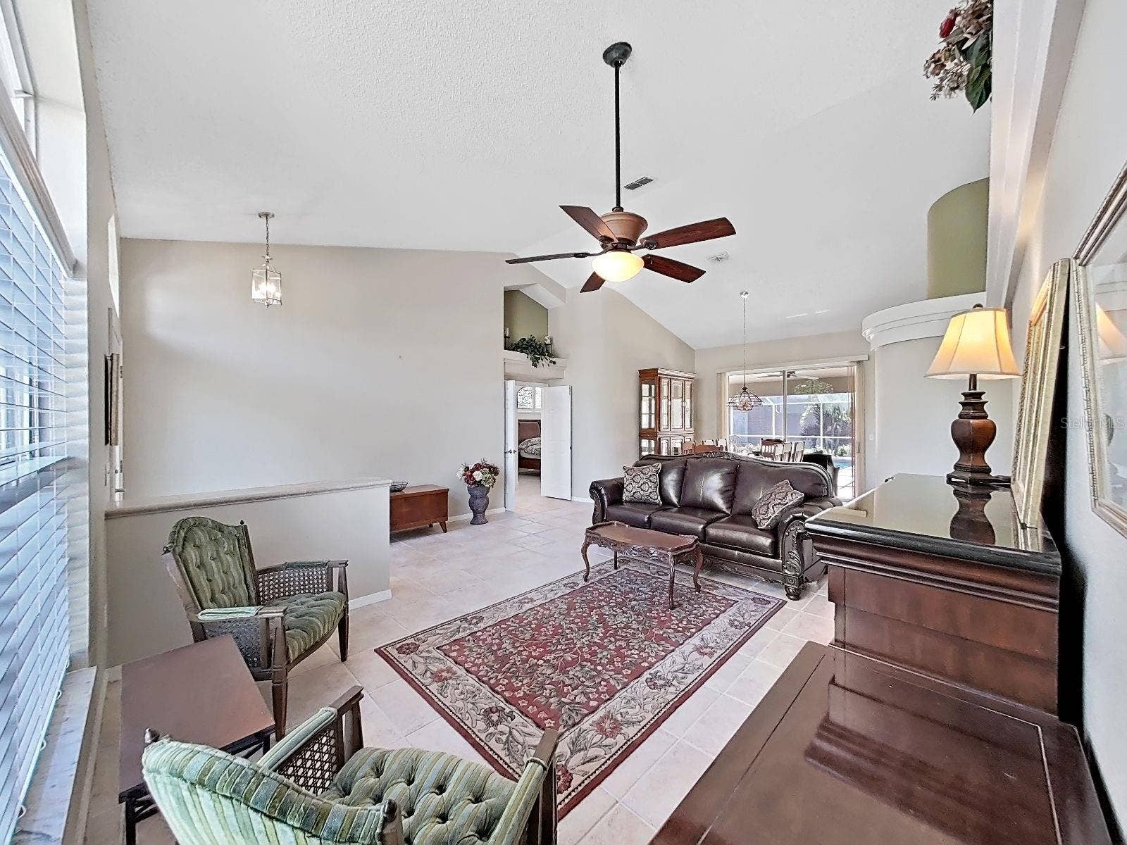15001 MEADOWLAKE STREET, Odessa, FL 33556 living rm, note double-door entry to primary bedroom suite, dining room with sliders to pool area and great view of the back yard